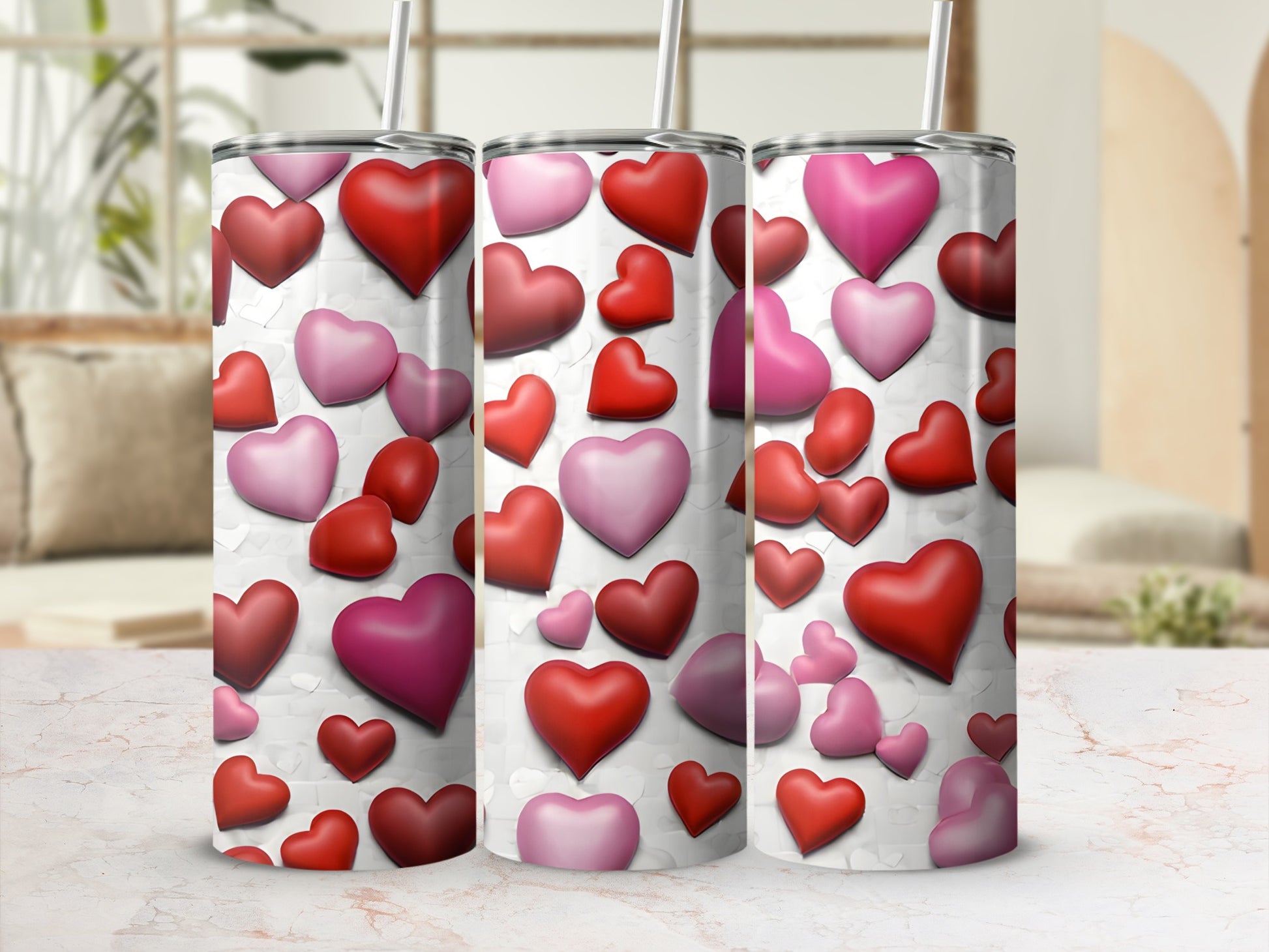 Three tumblers with various shades of pink and red hearts on a white background.