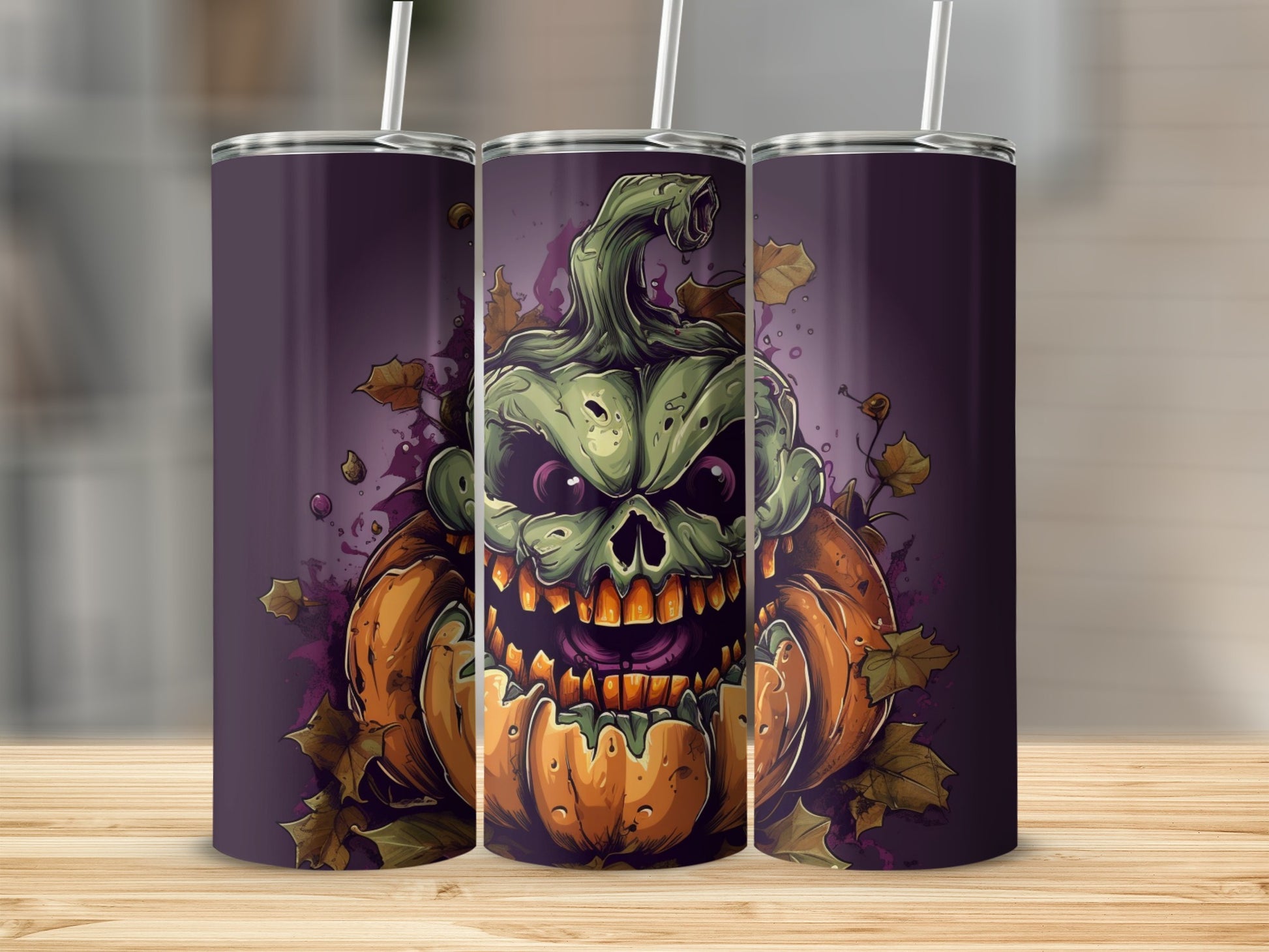 Three tumblers displaying a scary, green pumpkin-skull with autumn leaves.