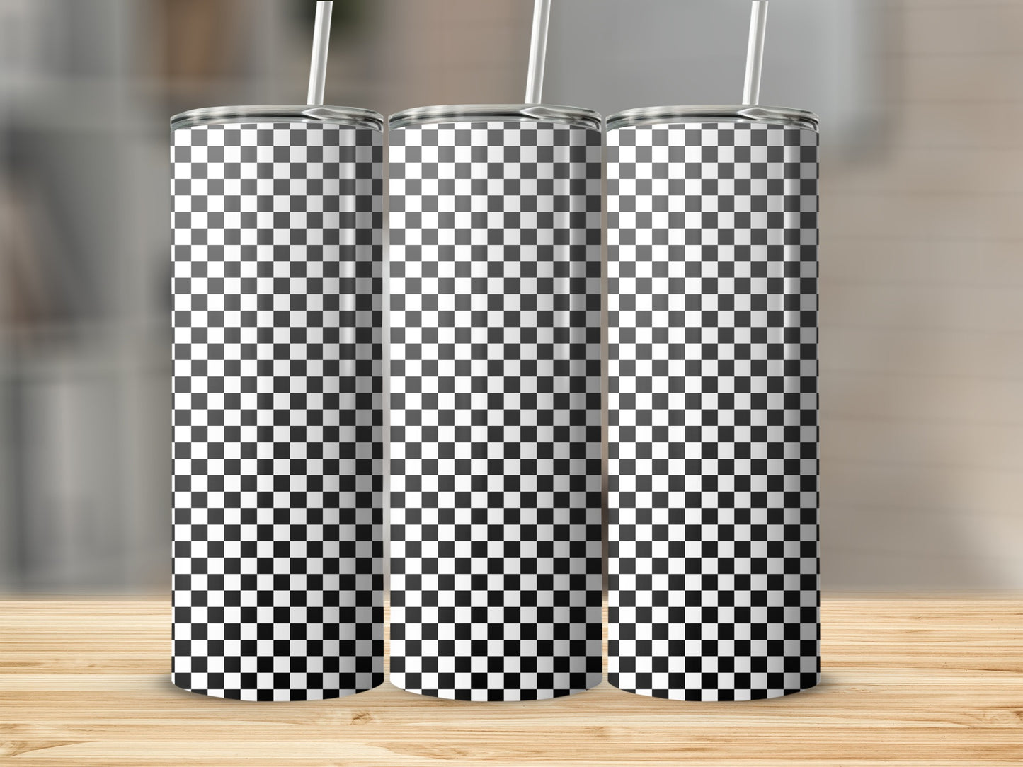 Three tumblers with black and white checkered pattern and straws.