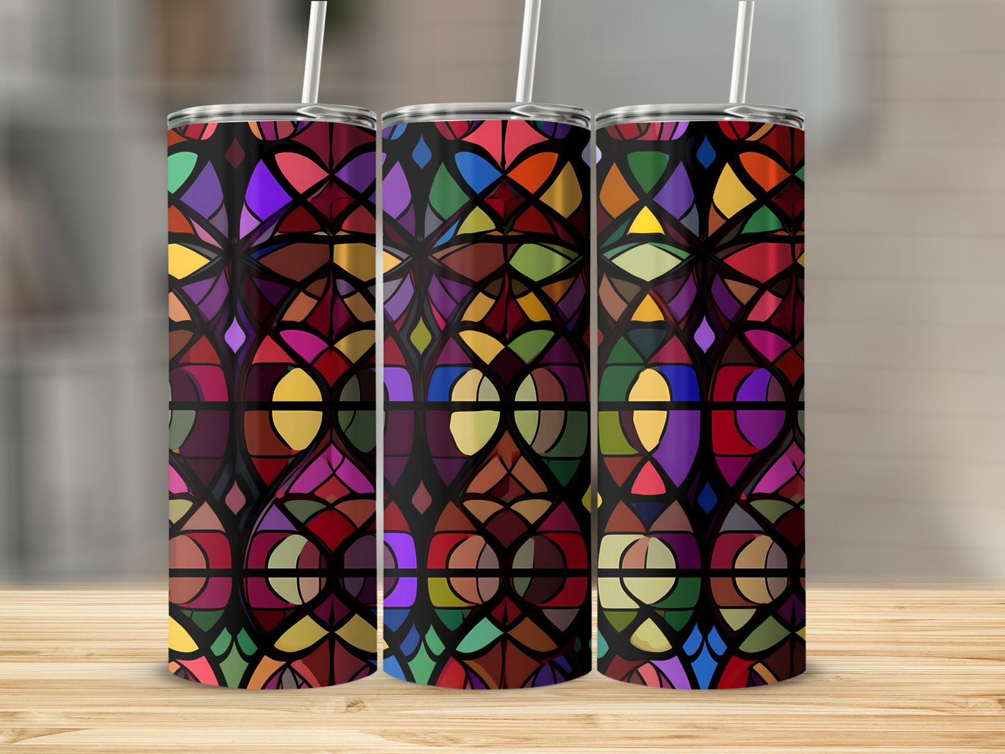 Three tumblers with colorful stained glass patterns on a wooden surface.
