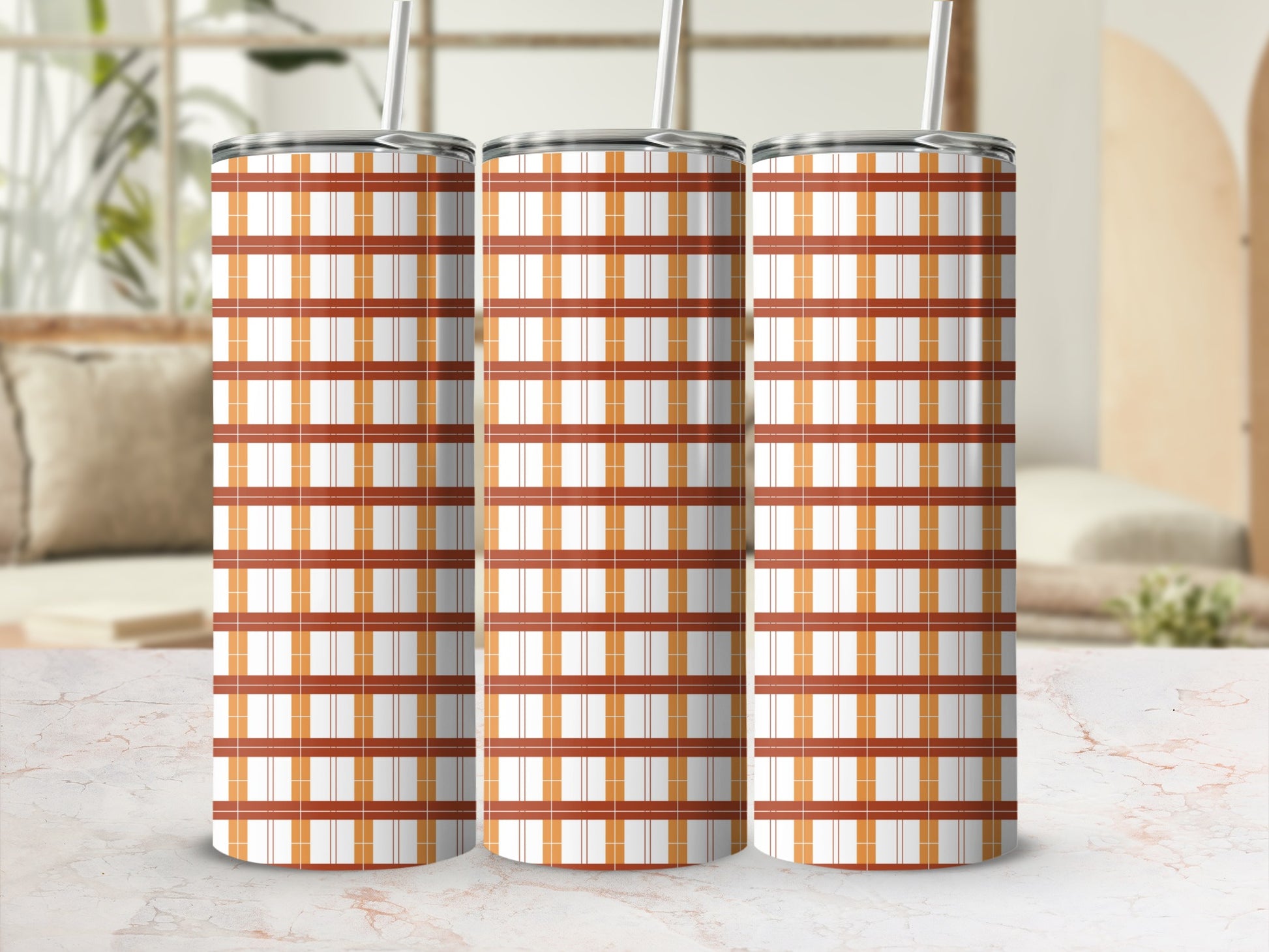 Three tumblers with orange and white plaid pattern and straw.