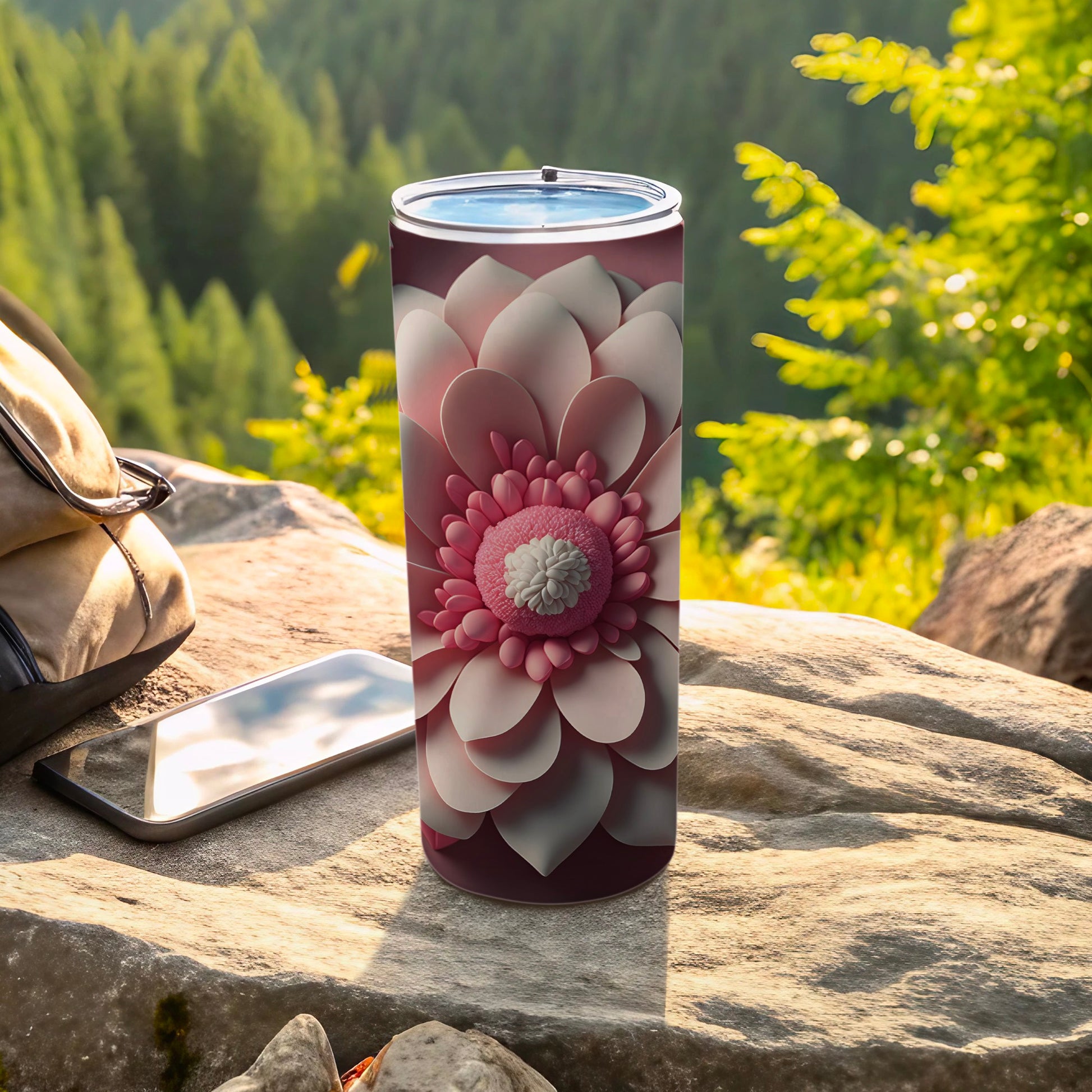 Pink floral pattern on a stainless steel tumbler with phone and bag.