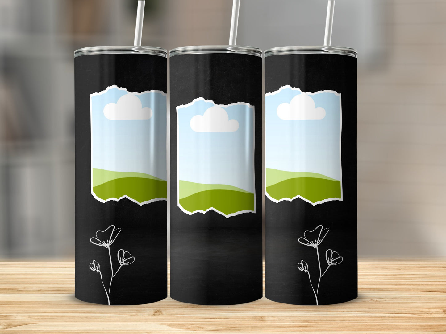 Three black tumblers with torn paper design showing sky, clouds, and green hills.