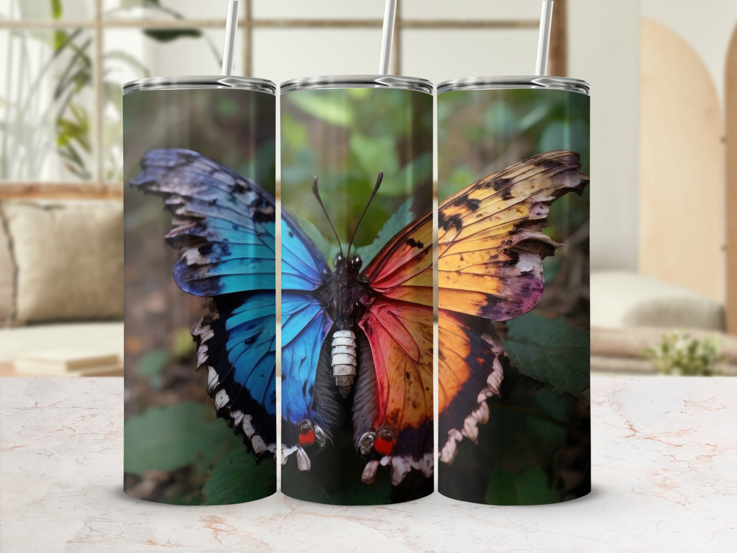 Split butterfly graphic with blue and orange wings on three tumblers.
