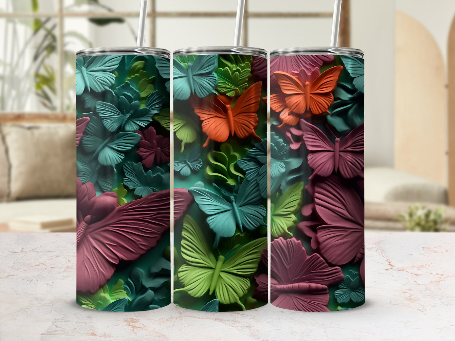 Three colorful butterfly tumblers with textured designs in shades of green, pink, and orange.