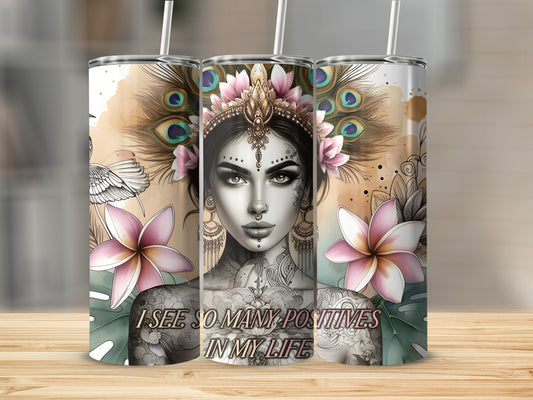 Tumbler with a woman's face, feathers, flowers, and text "I SEE SO MANY POSITIVES IN MY LIFE."