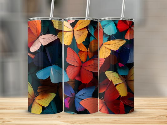 Three tumblers with colorful butterfly patterns and straws.