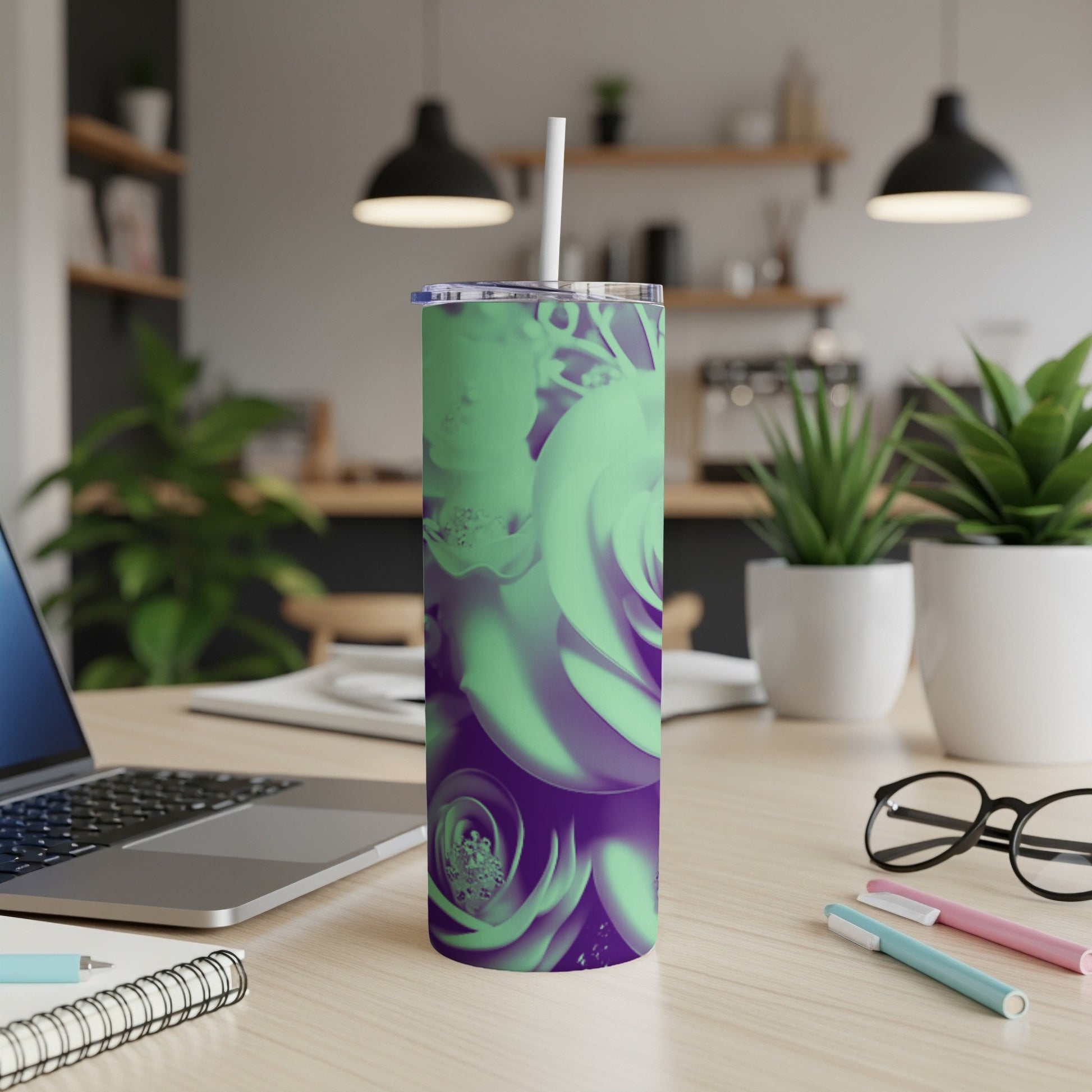 Purple and green floral print insulated tumbler with straw on a desk.