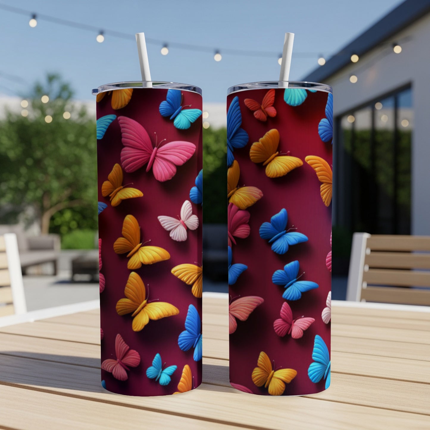 Two colorful butterfly-patterned tumblers on a wooden table.