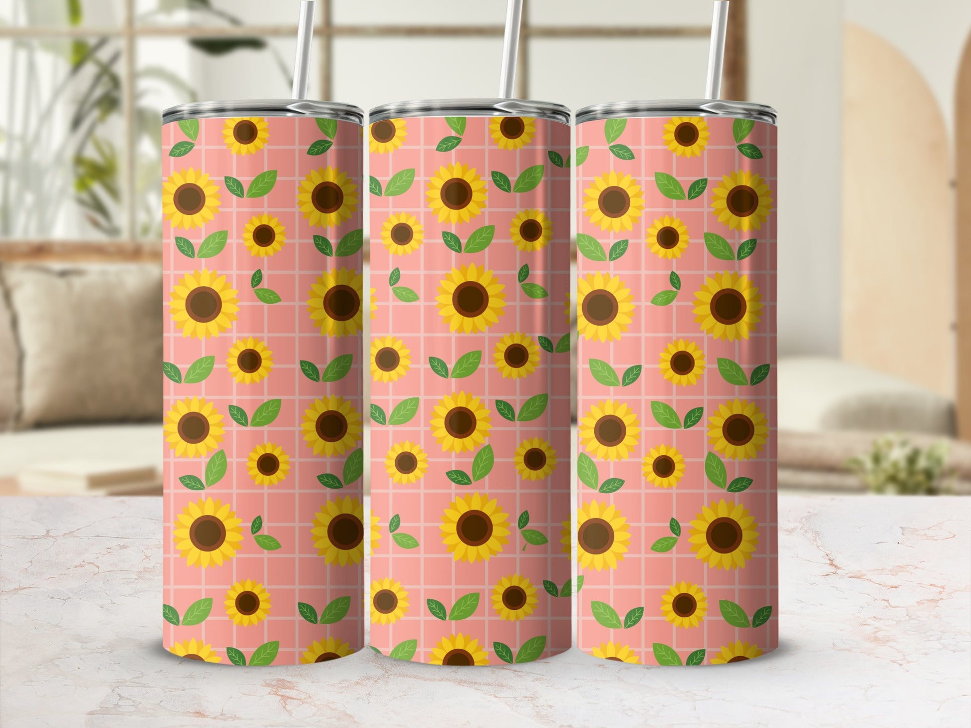 Three tumblers with a seamless sunflower and leaf pattern on a pink grid.