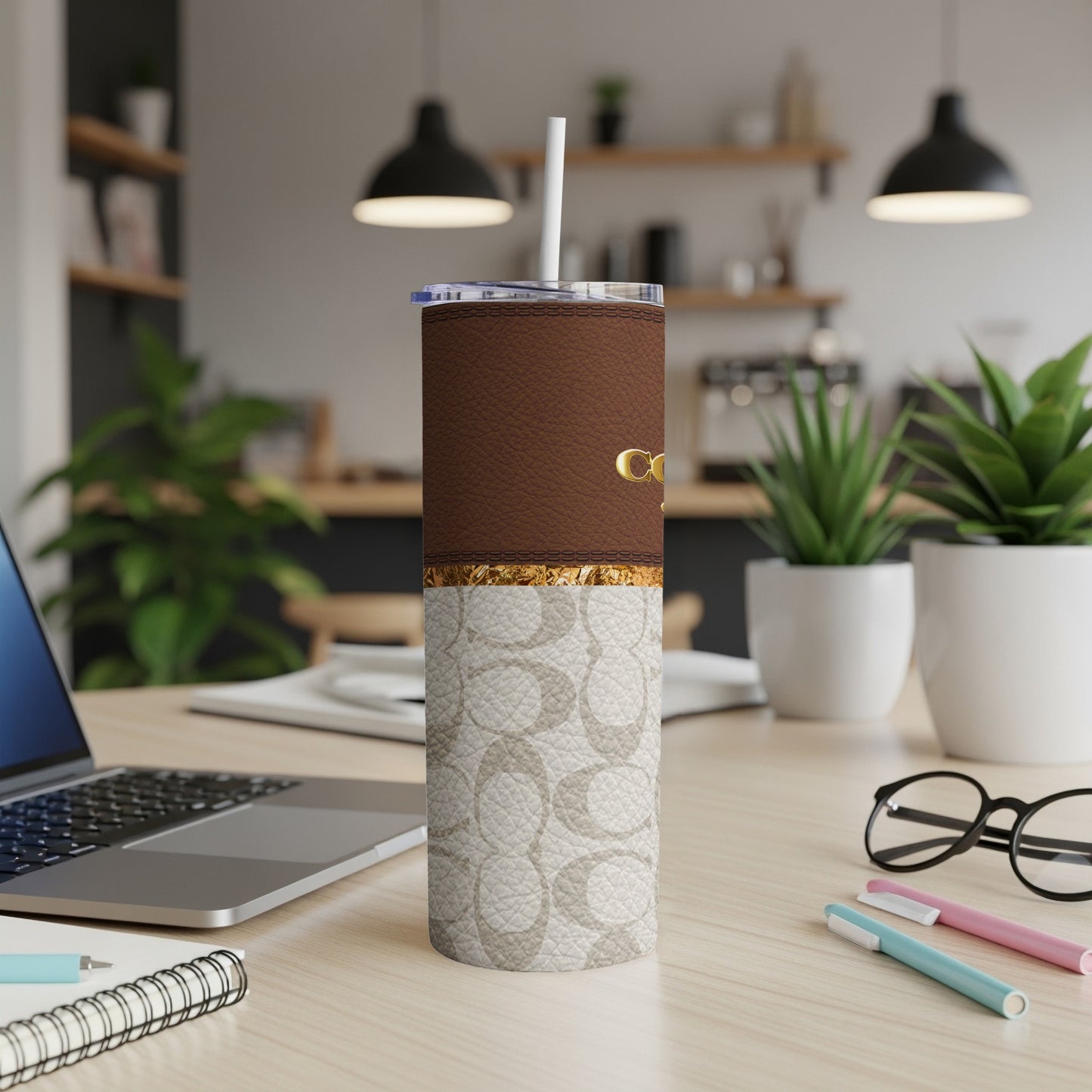 Coach tumbler with brown leather top and logo print bottom.