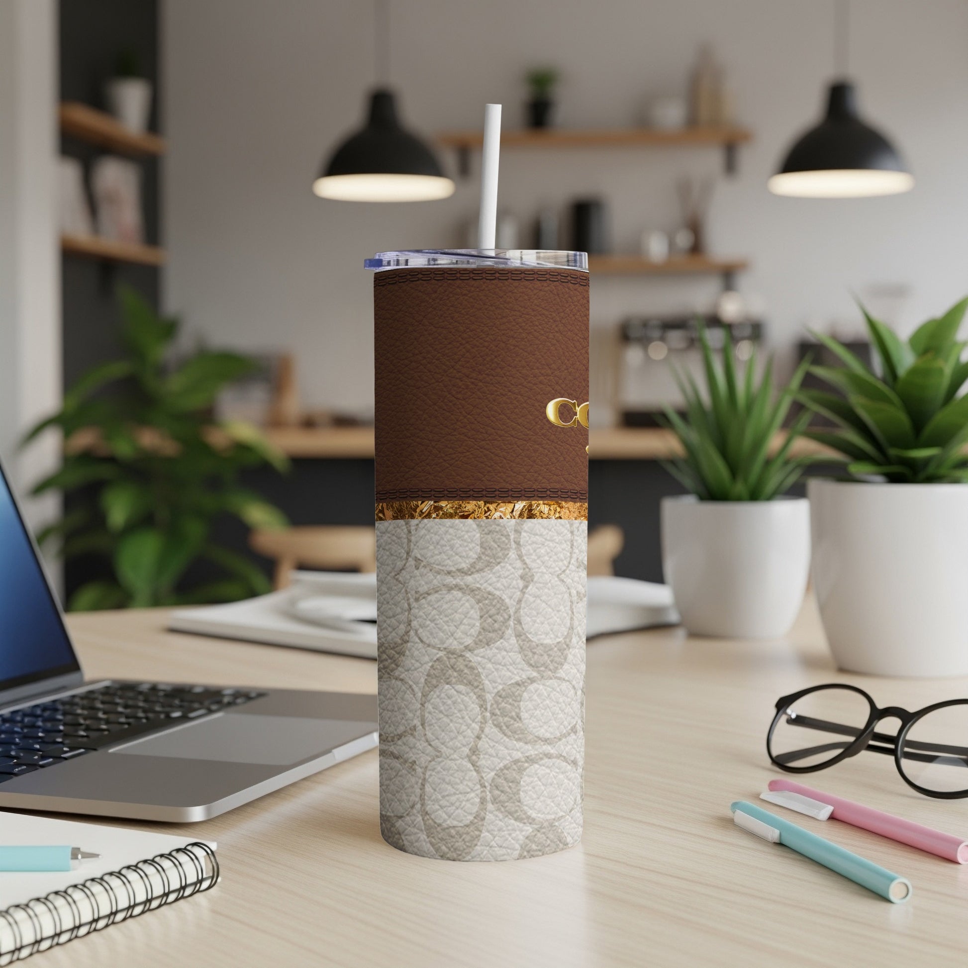 Coach tumbler with brown leather top and logo print bottom.