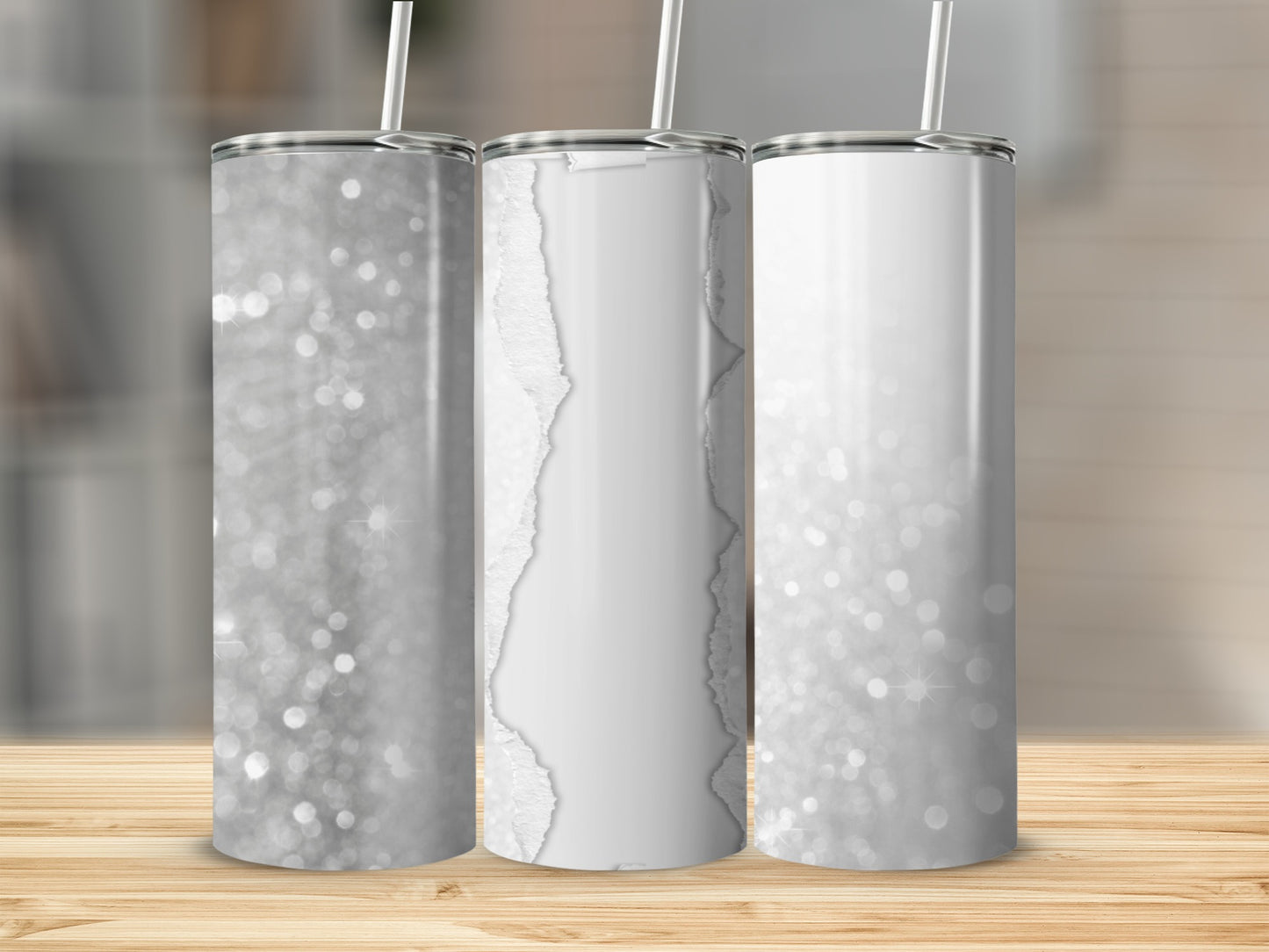 Three glittery white tumblers with straws on a wooden surface.