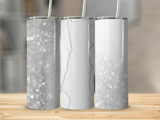 Three glittery white tumblers with straws on a wooden surface.