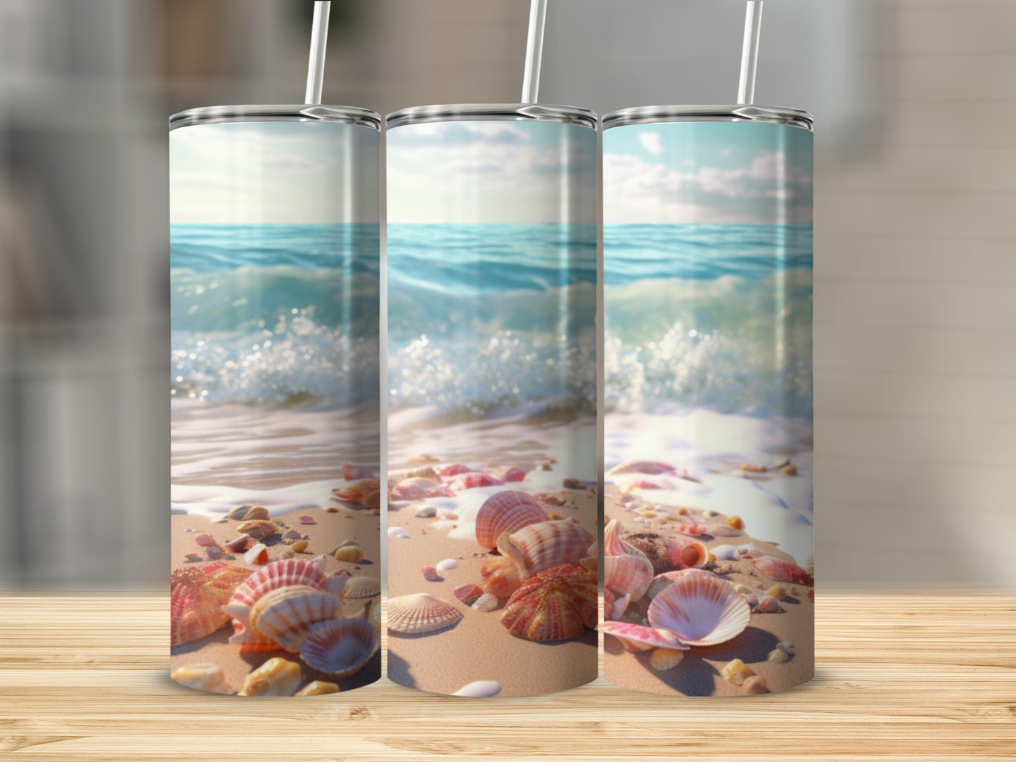 Three tumblers with seashells and ocean waves on a wooden surface.