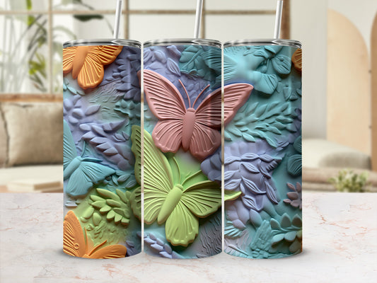 Three tumblers with butterfly and floral embossed designs in pastel colors.