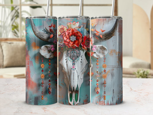 Floral-decorated cow skull with colorful embellishments on a teal background.