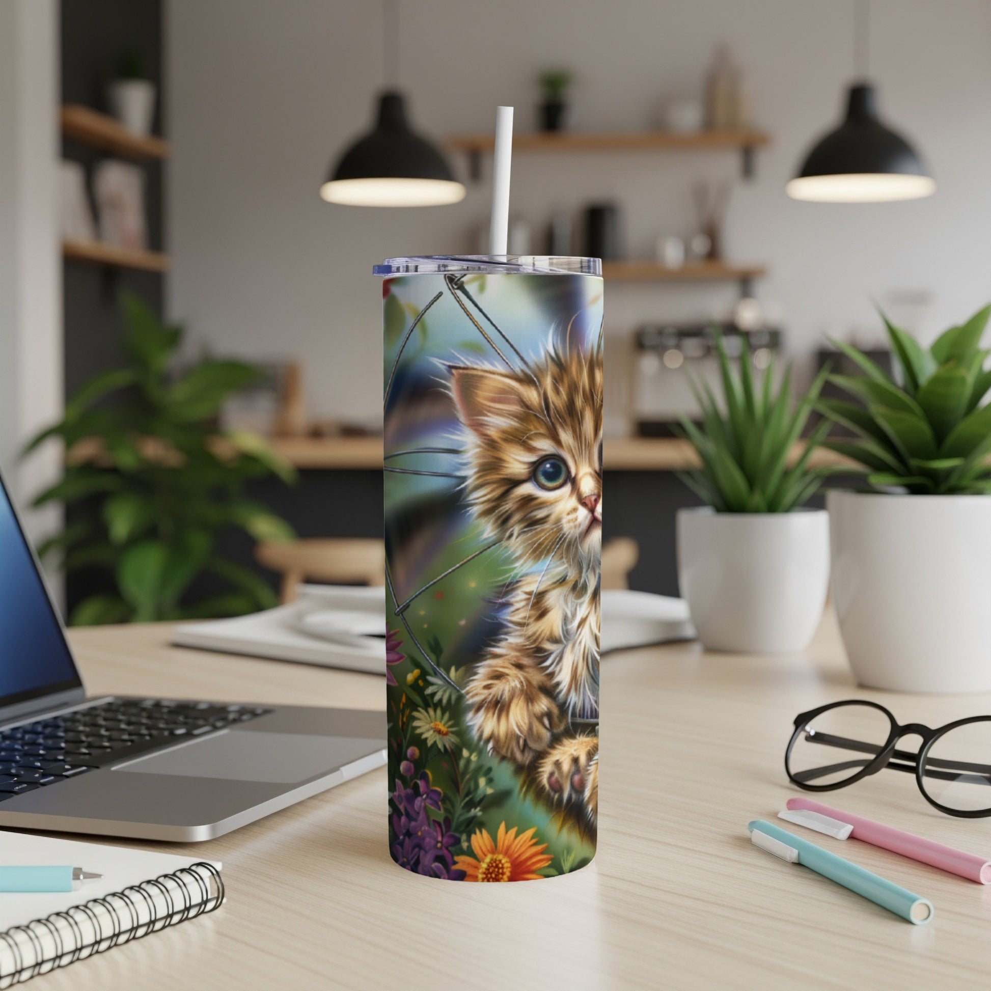 Furry kitten peeking through flowers on a colorful tumbler.