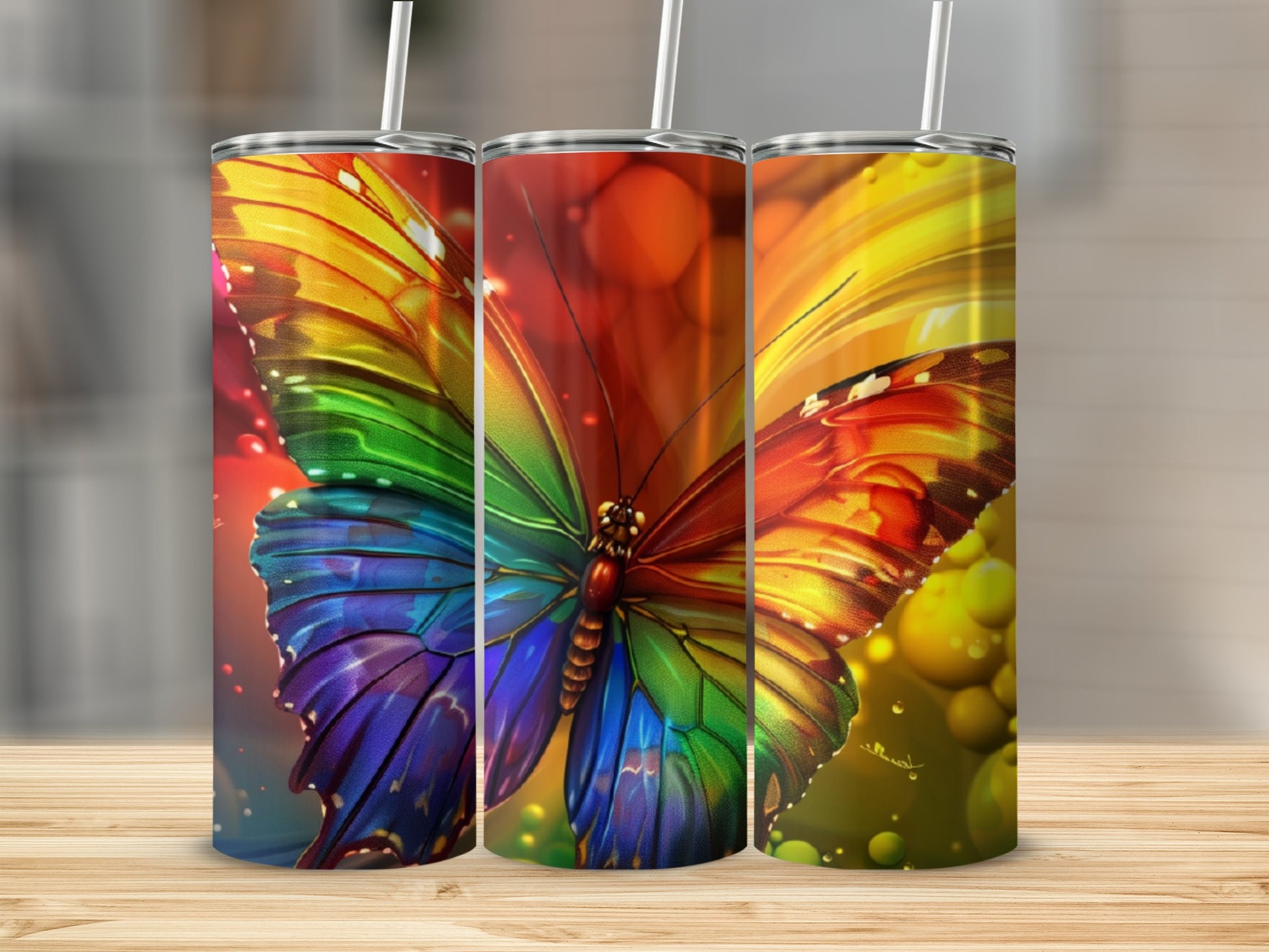 Three tumblers featuring a vibrant rainbow butterfly design with bokeh lighting.