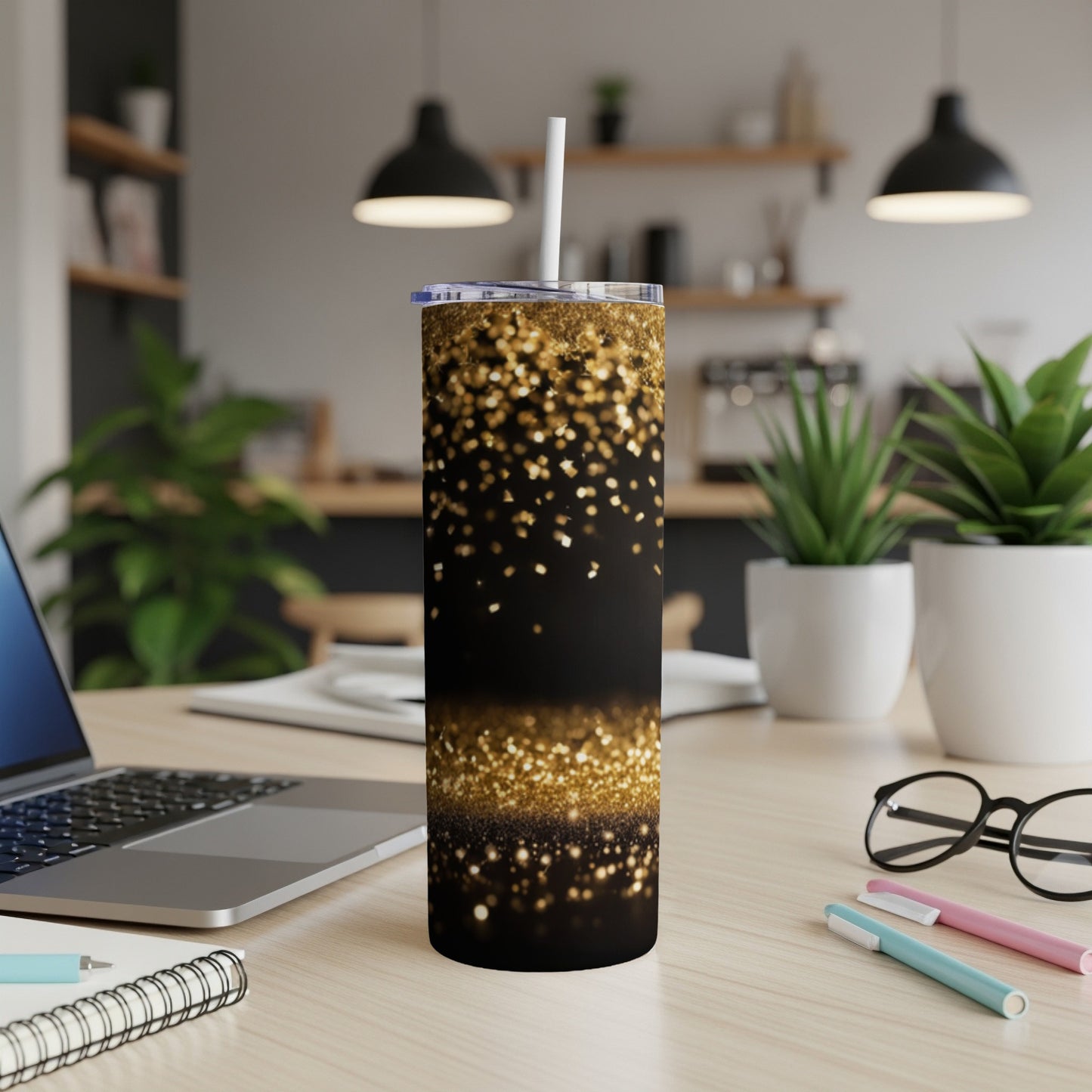Black tumbler with gold glitter accents and a white straw.