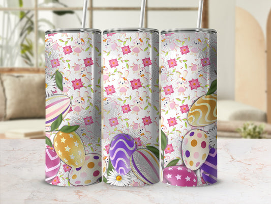 Three tumblers with Easter egg and bunny patterns on a marble surface.
