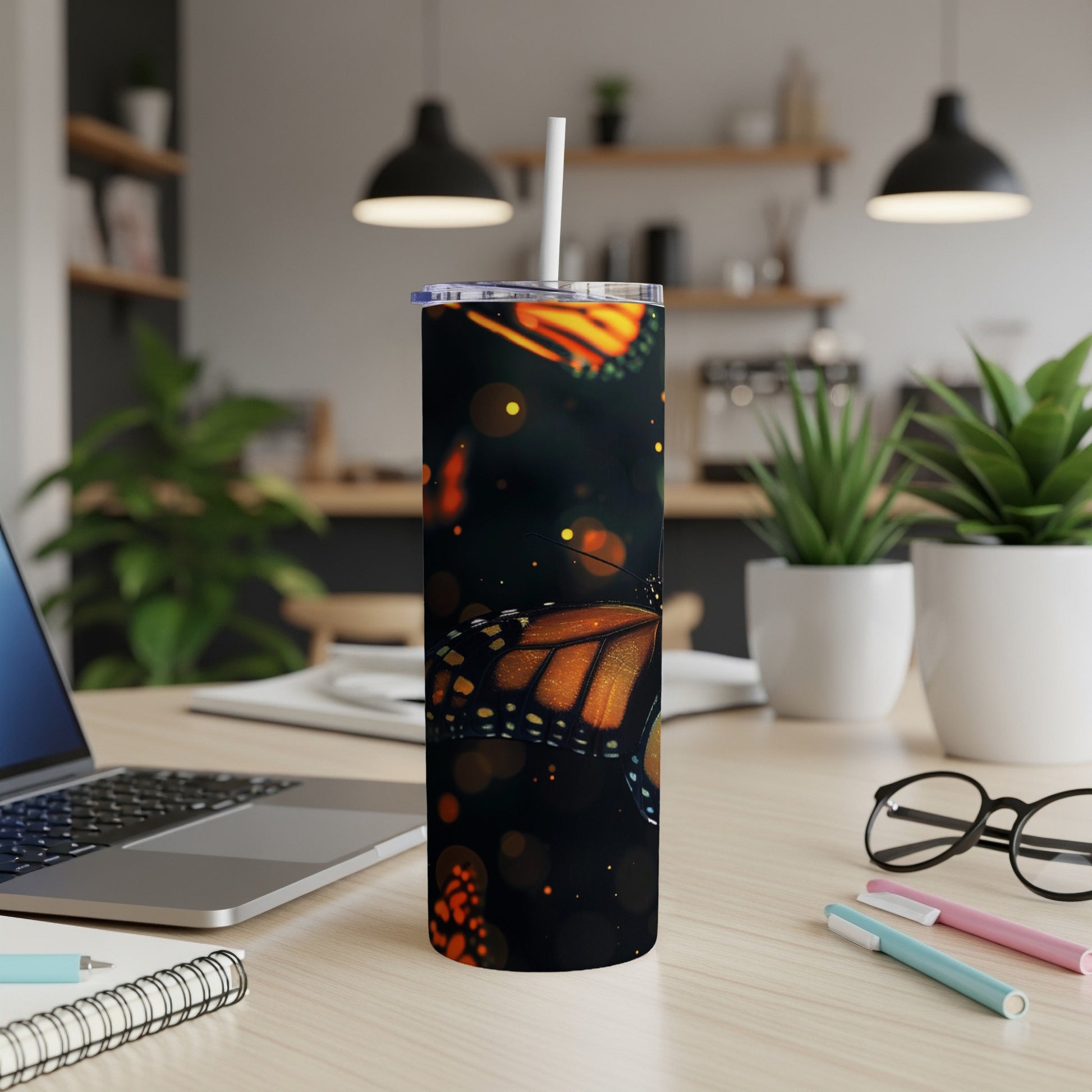 Monarch butterfly pattern on a black tumbler with a straw.