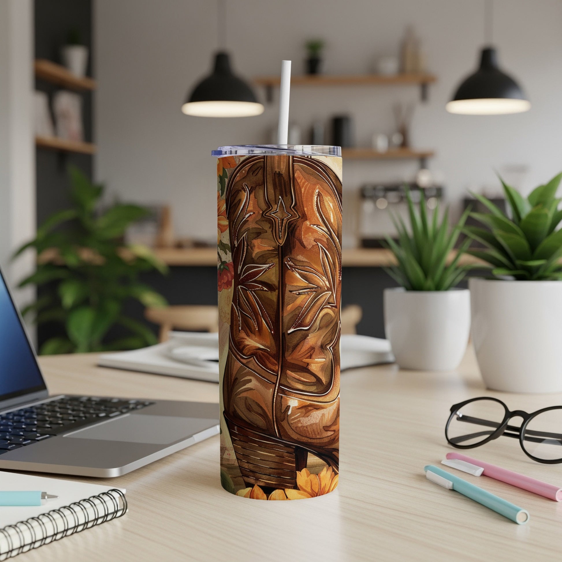 Brown cowboy boot tumbler with floral accents on desk.