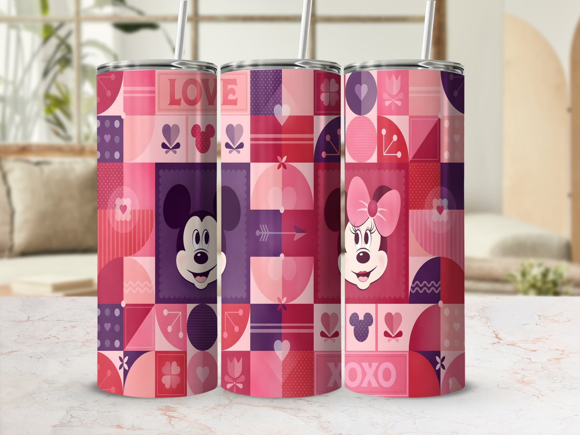 Three pink and purple geometric Minnie Mouse tumblers with straws on a white surface.