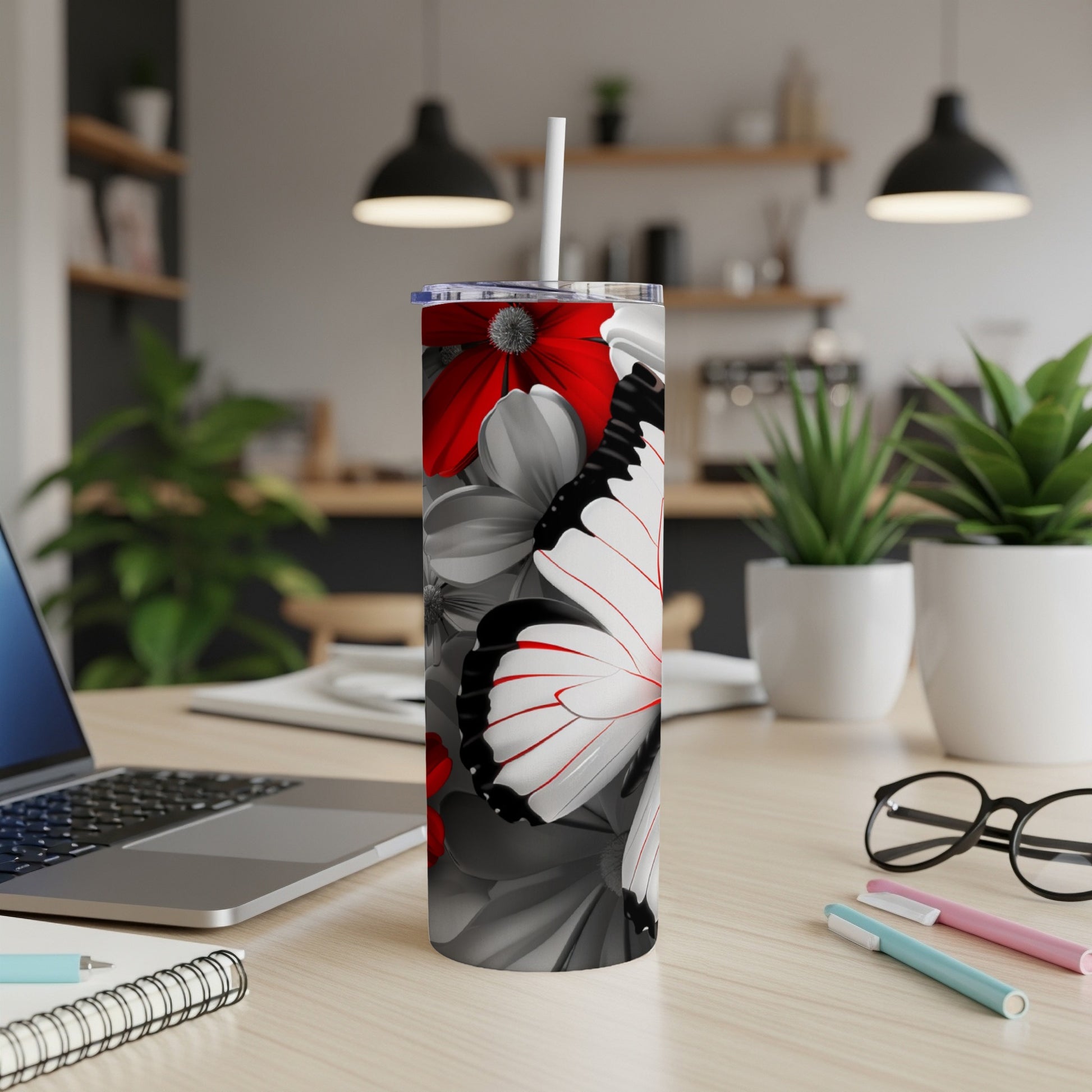 White butterfly with red accents on a floral patterned tumbler.