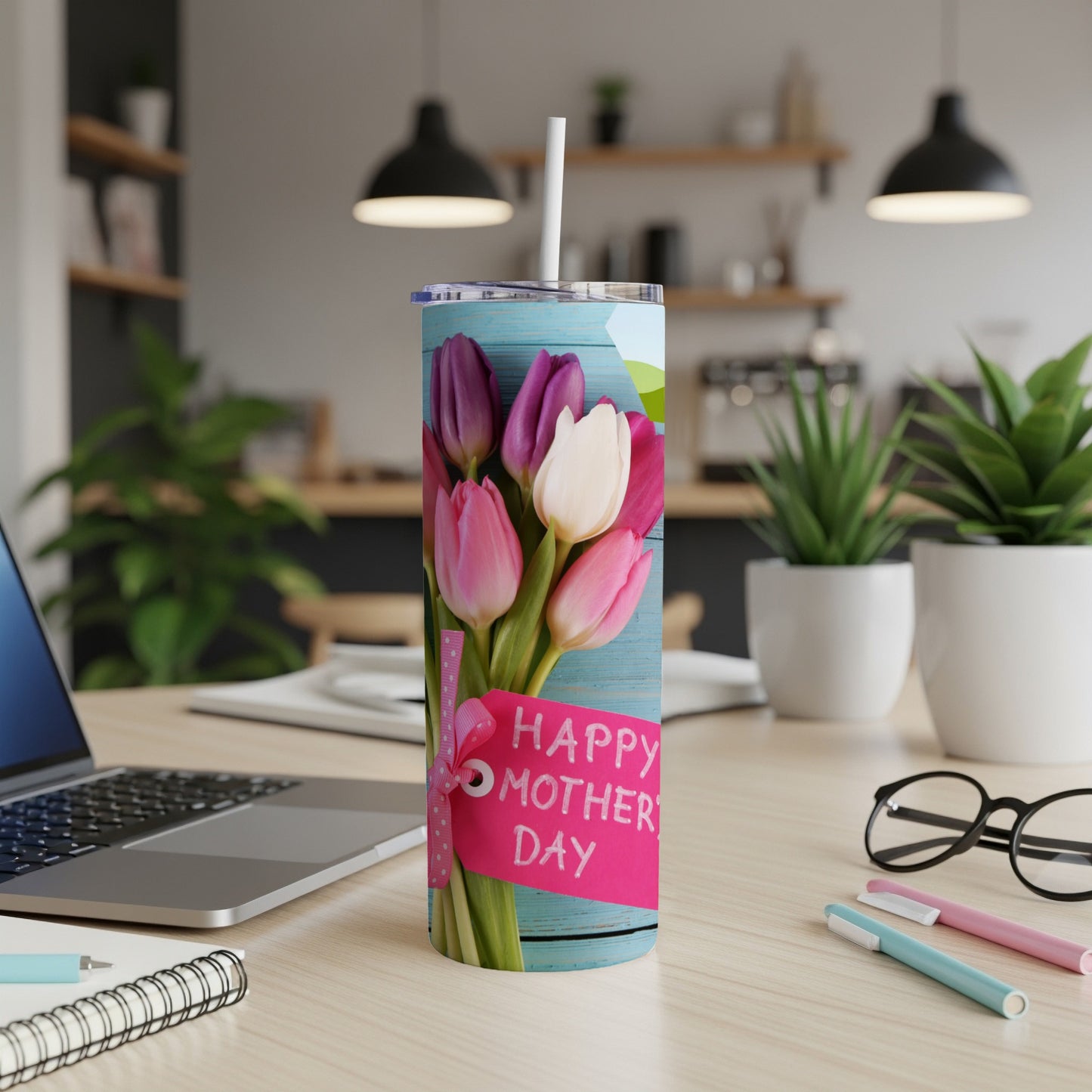 Tumbler with pink and purple tulips and a "Happy Mother's Day" tag on a desk.