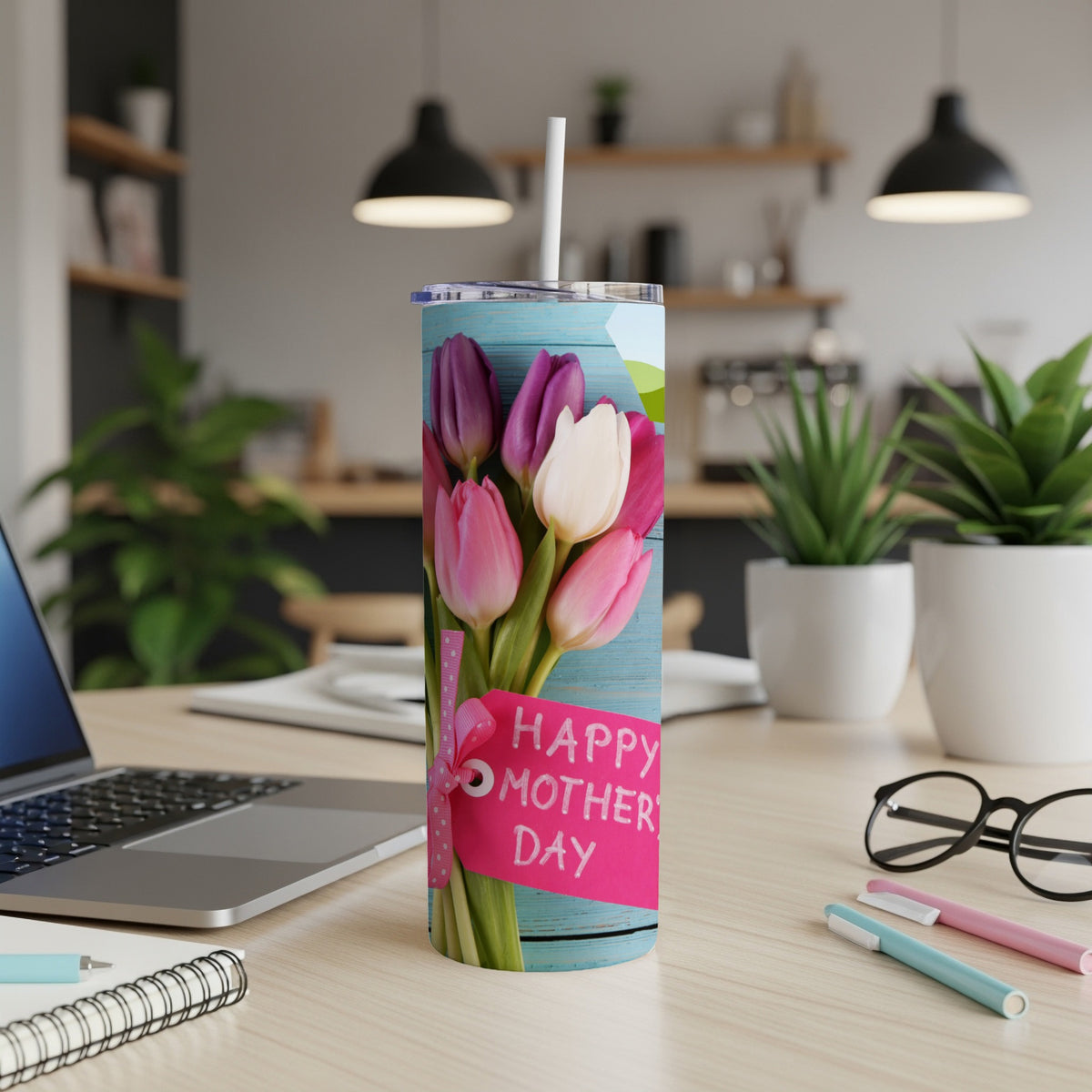 Tumbler with pink and purple tulips and a "Happy Mother's Day" tag on a desk.