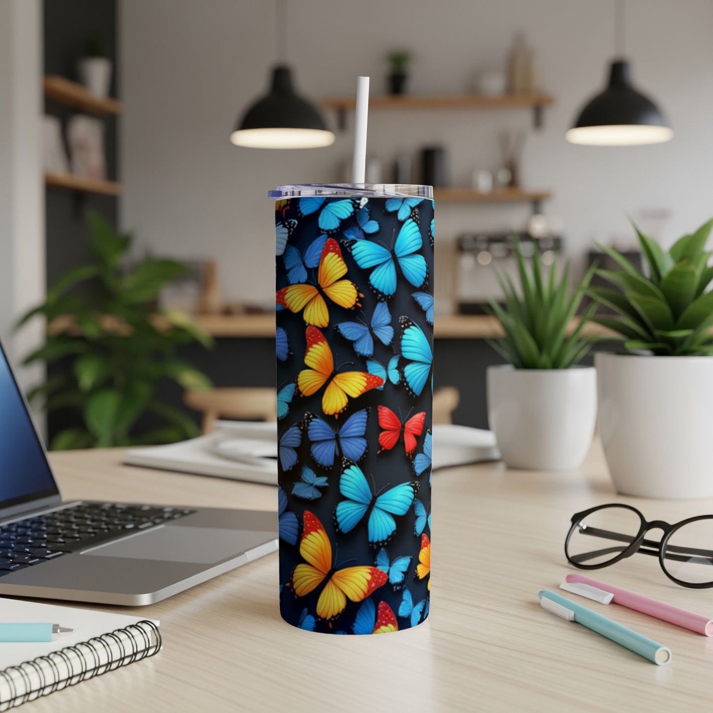 Tumbler with colorful butterfly design on a desk.