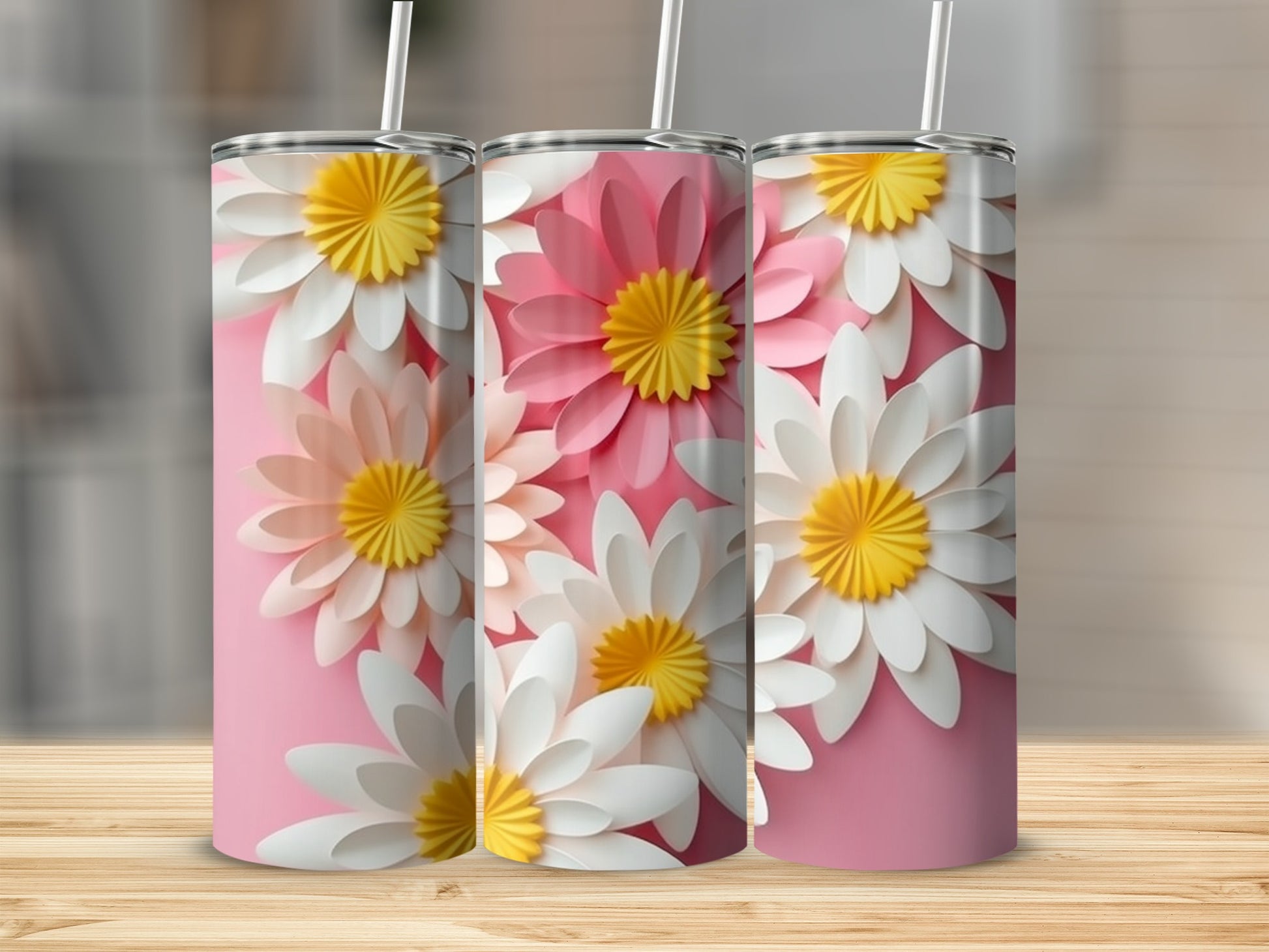 Three tumblers with floral designs on a pink background.