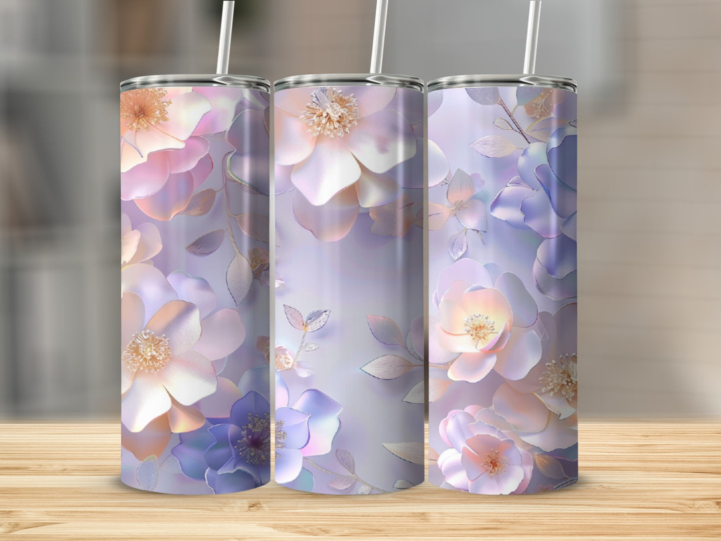 Three tumblers with pastel floral design on a wooden surface.