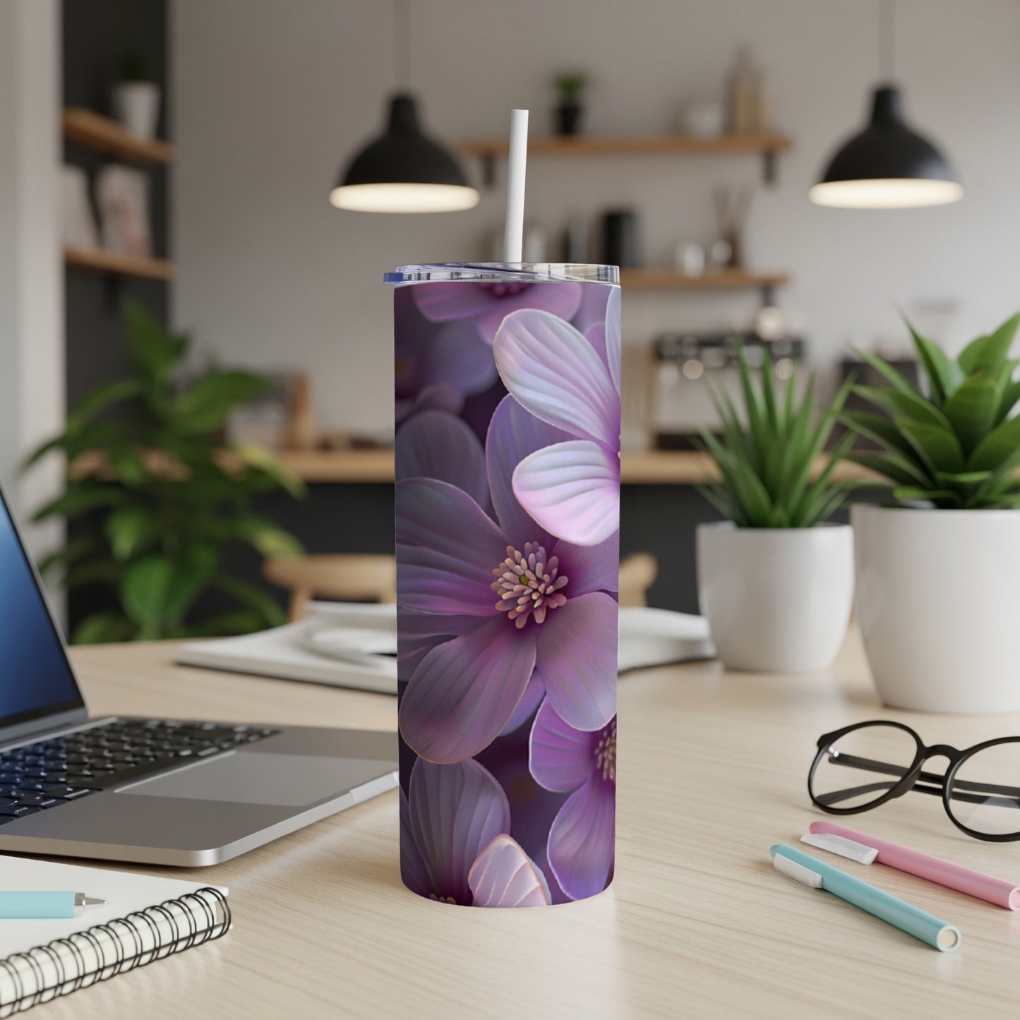 Purple floral tumbler with straw on a desk.