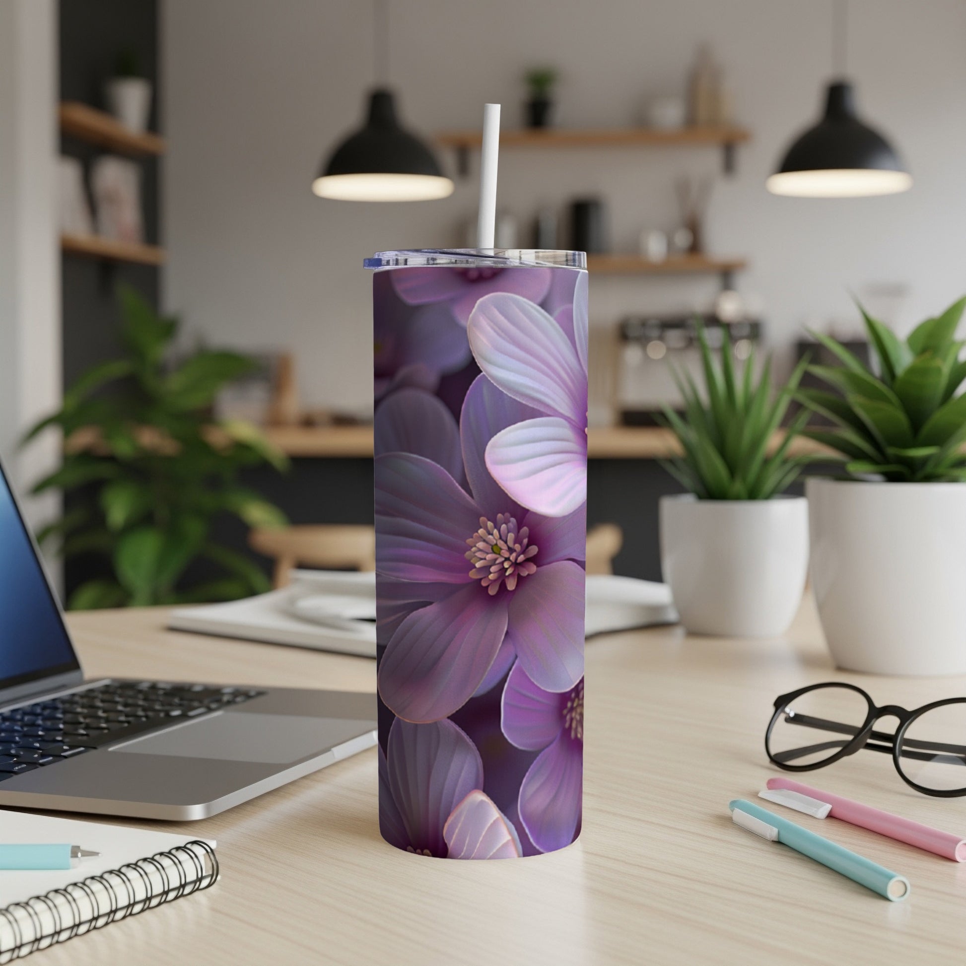 Purple floral tumbler with straw on a desk.