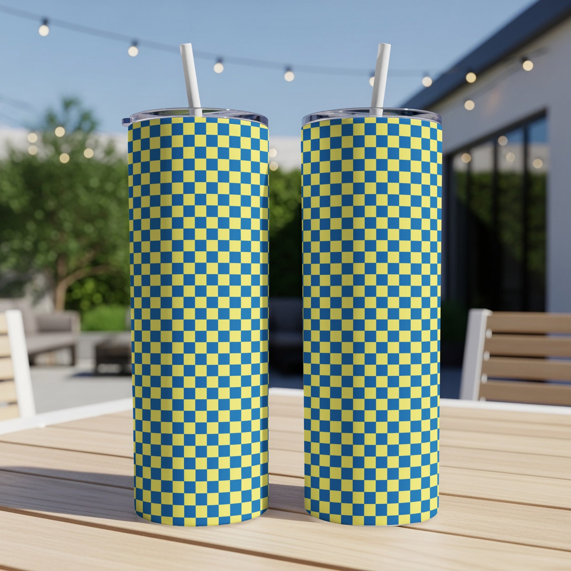 Two tall tumblers with a blue and yellow checkered pattern, with straws.