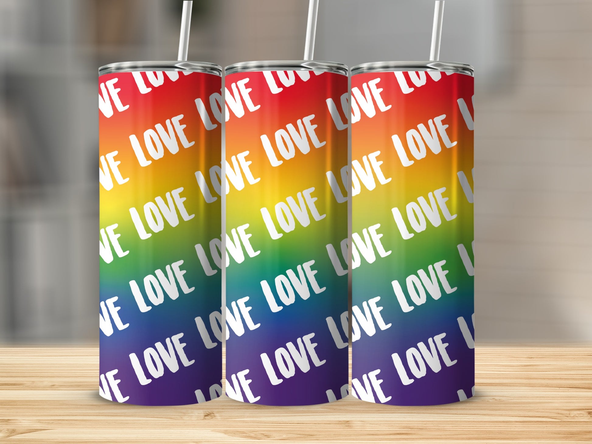 Three tumblers with rainbow stripes and "LOVE" repeated across them.