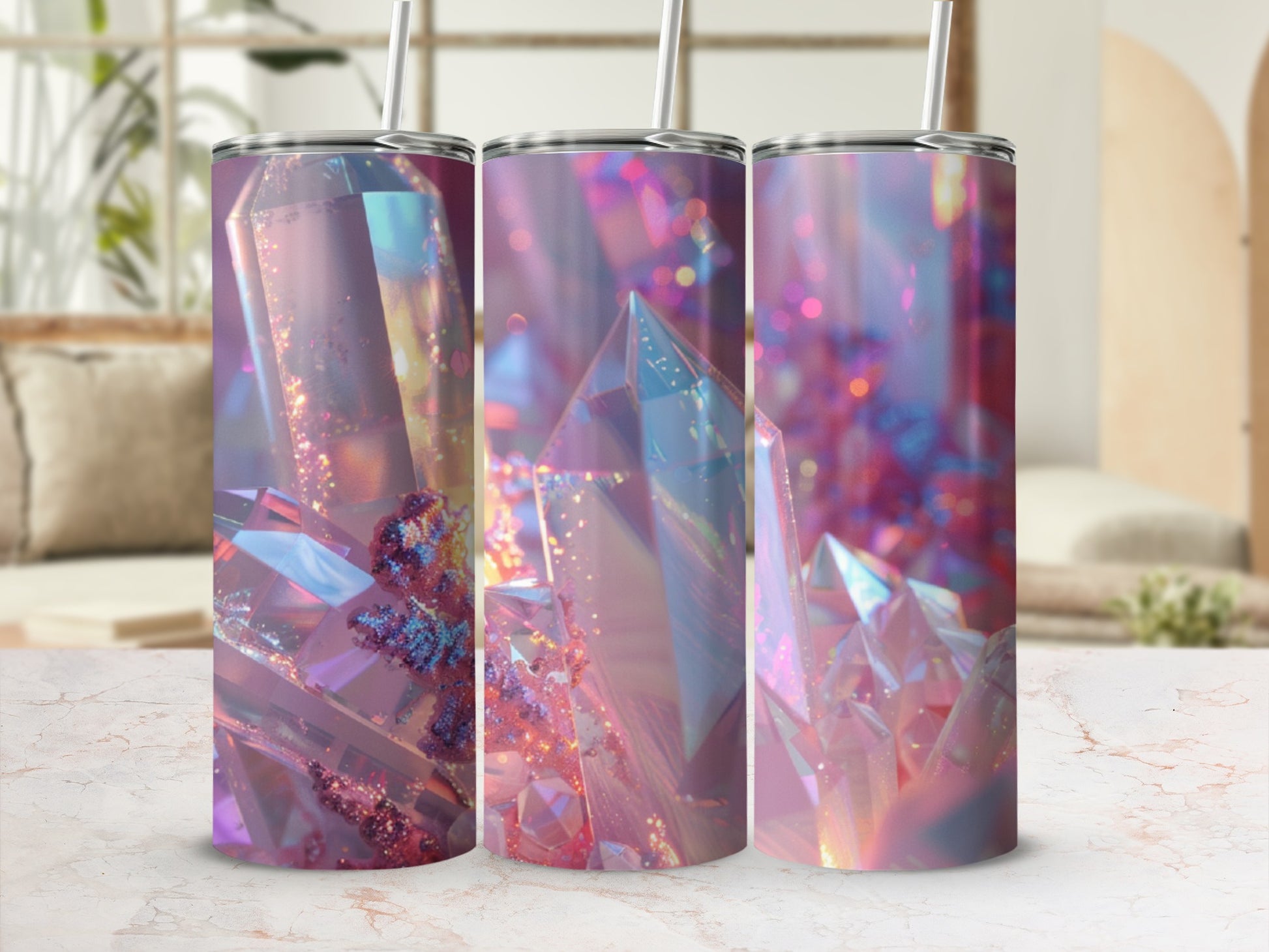 Three tumblers with iridescent crystal designs on a marble surface.