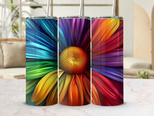 Three colorful floral tumblers with straws displayed on a marble surface.