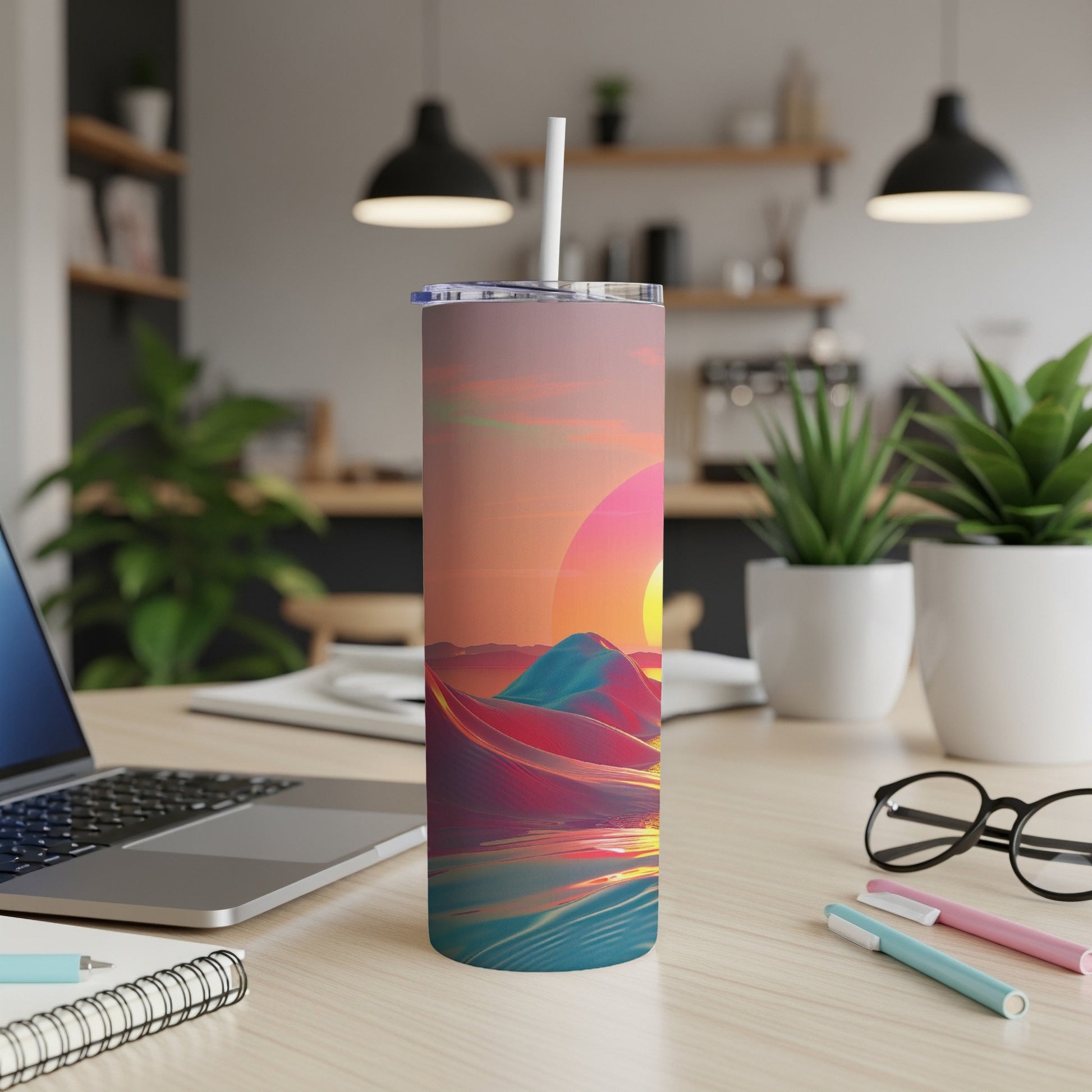 Tumbler with desert landscape and sunset, straw in lid.