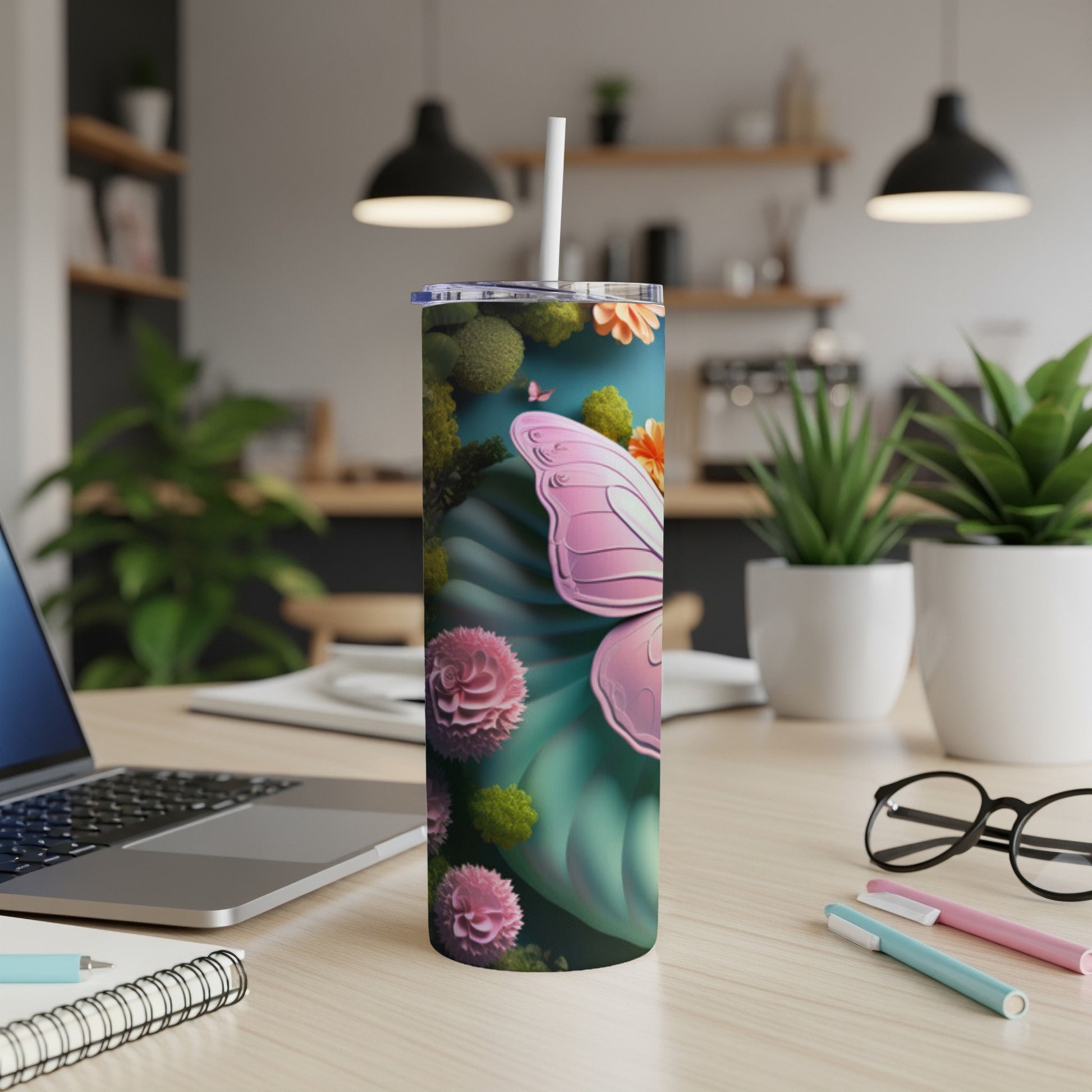 Pink butterfly wings and flowers on a teal background on a skinny tumbler.