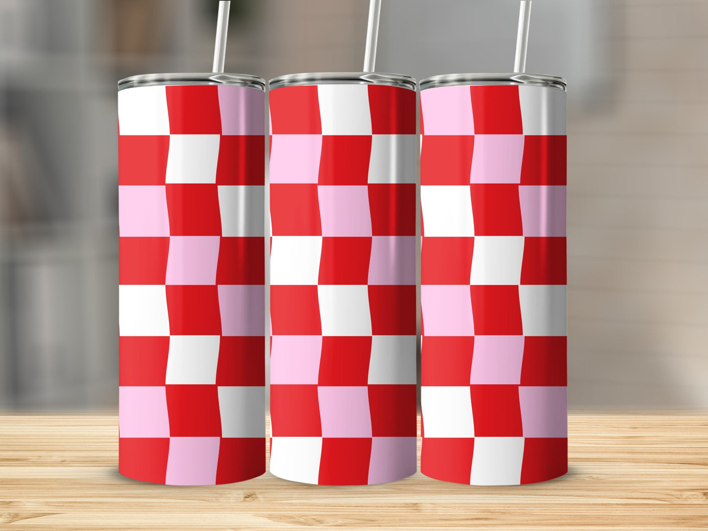 Three tumblers with a red and pink checkerboard pattern and white straws.
