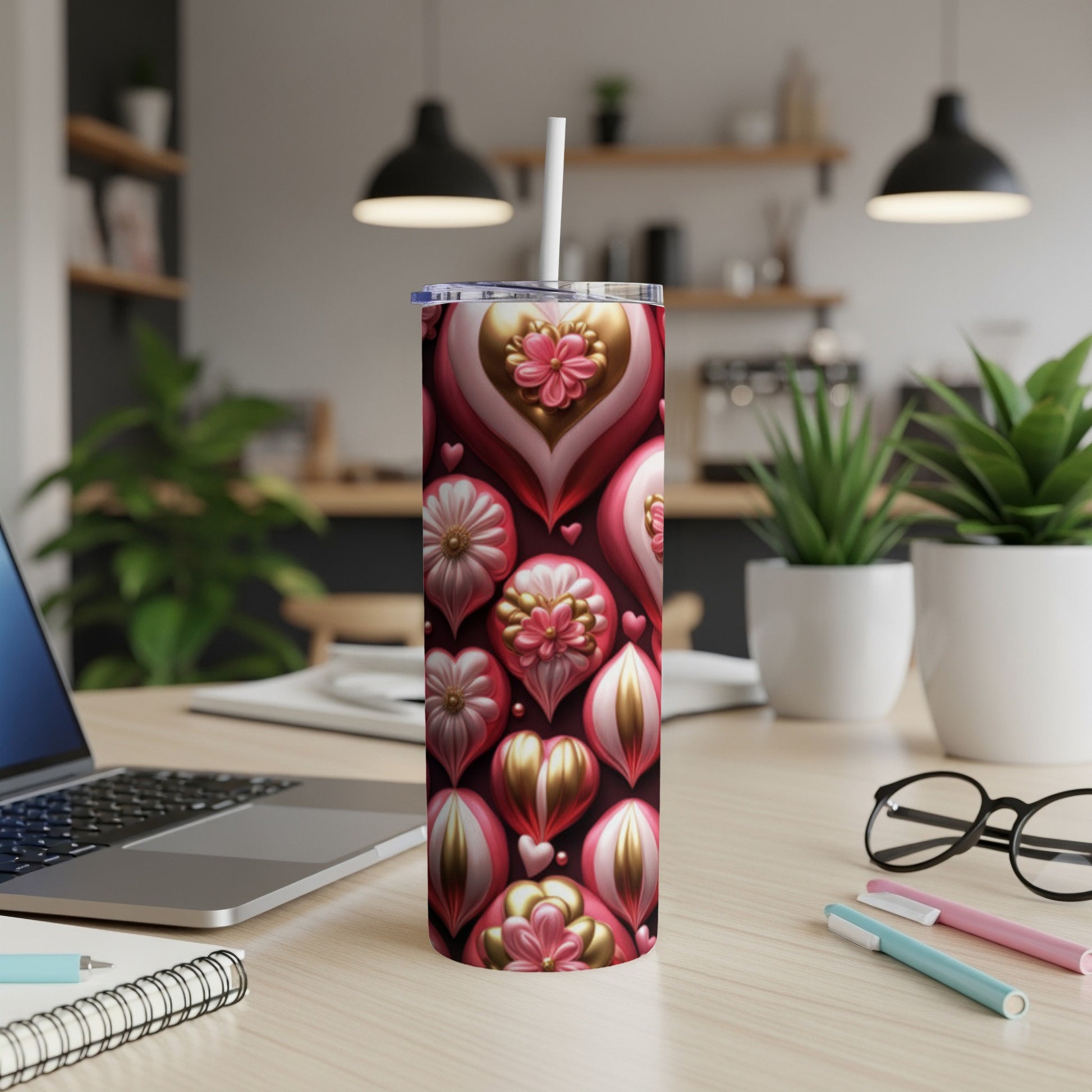Pink and gold heart-shaped ornaments adorn a tall tumbler with a straw.