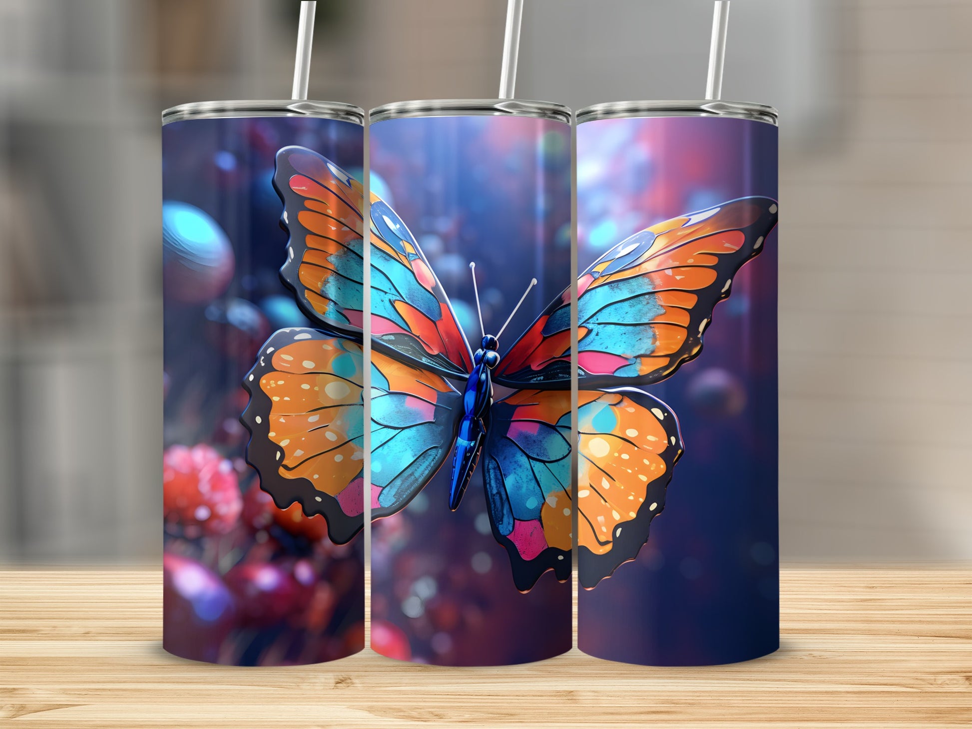 Three tumblers with a vibrant butterfly design on a wooden surface.