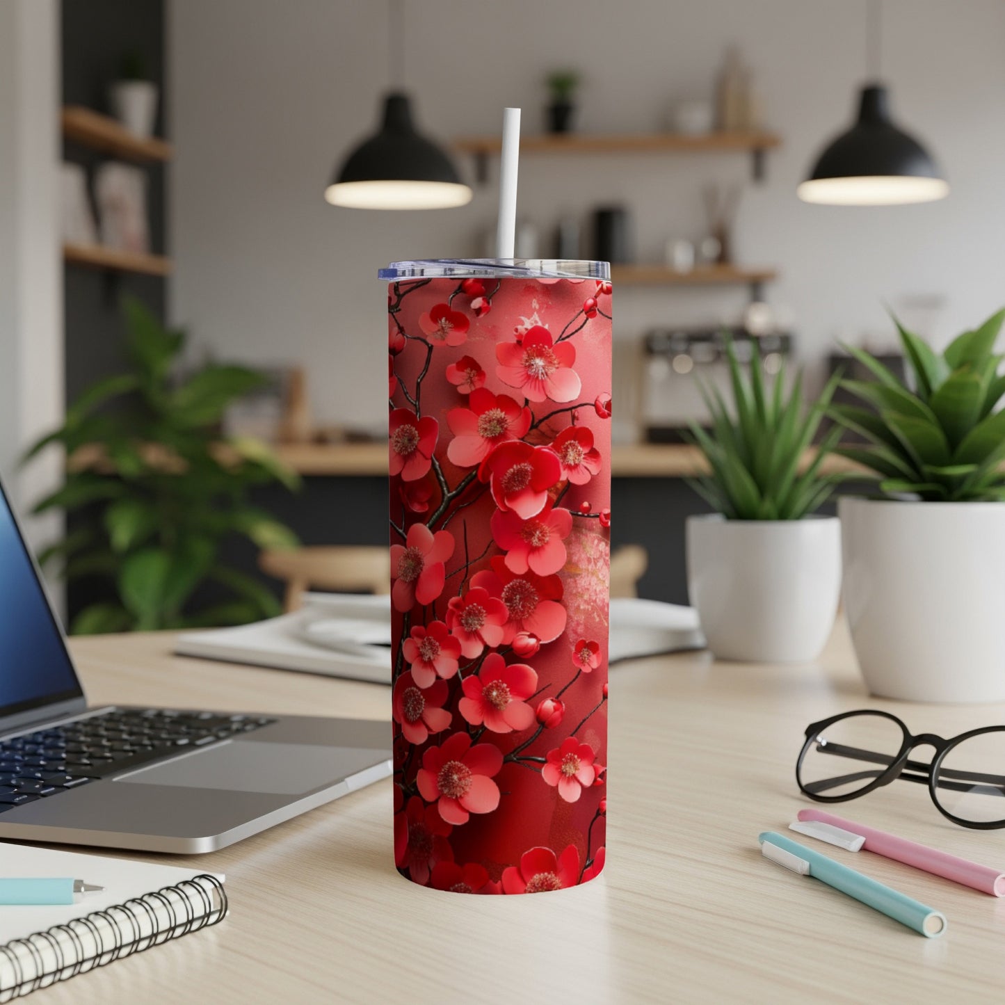 Red floral tumbler with white straw on a desk.