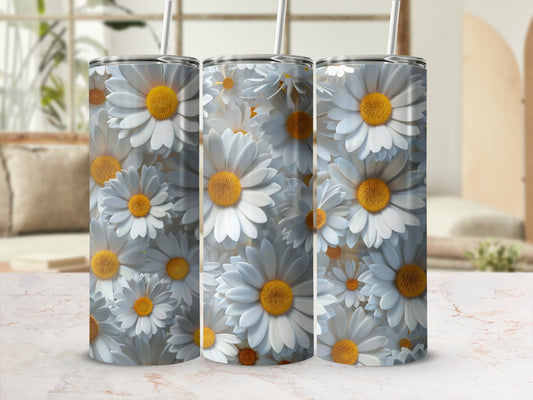 Three white daisies on a white tumbler with straws and a marbled surface.