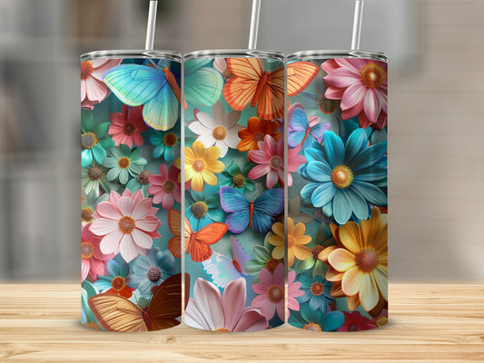 Three tumblers with colorful butterflies and flowers on a wooden surface.