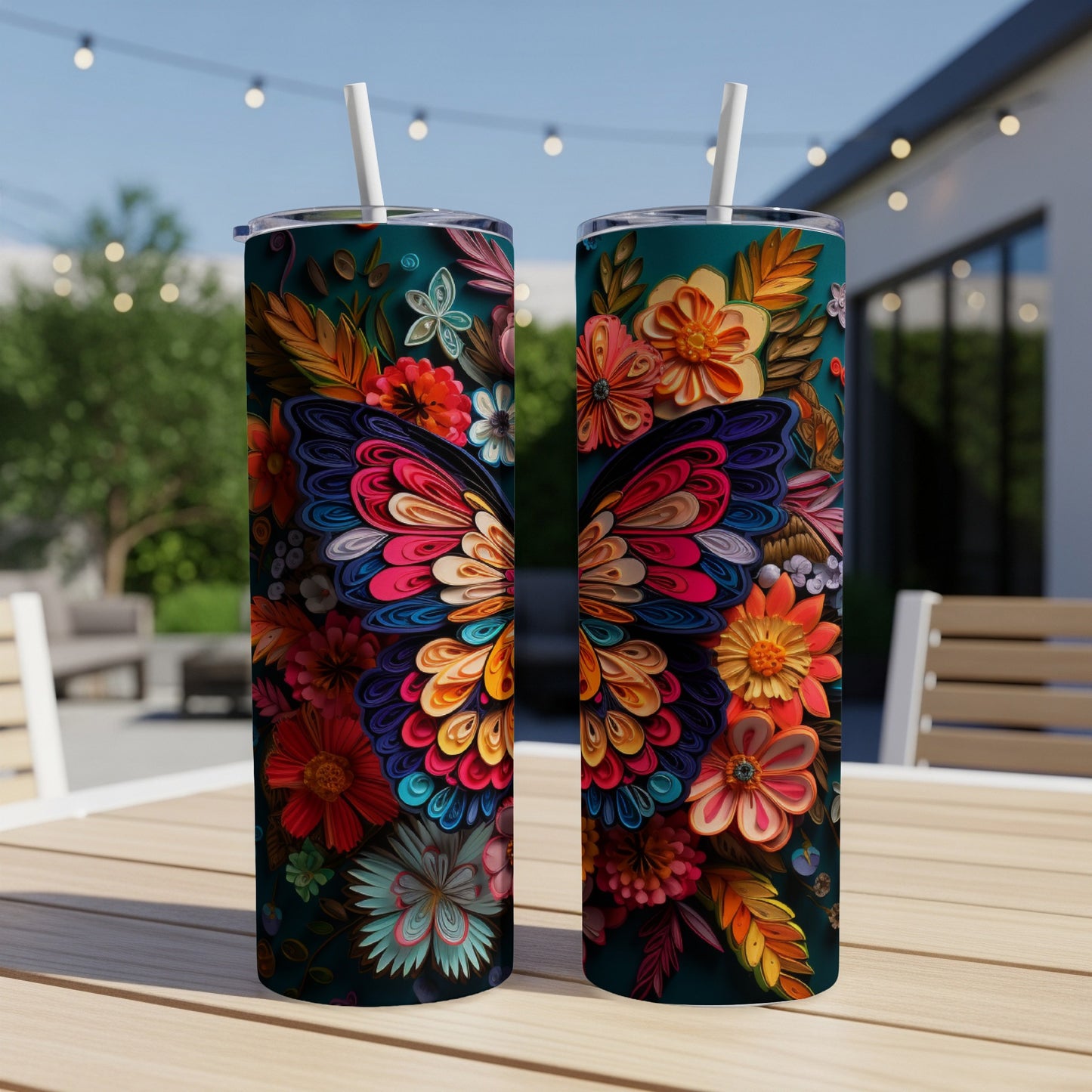 Two tumblers with vibrant floral butterfly designs on an outdoor table.