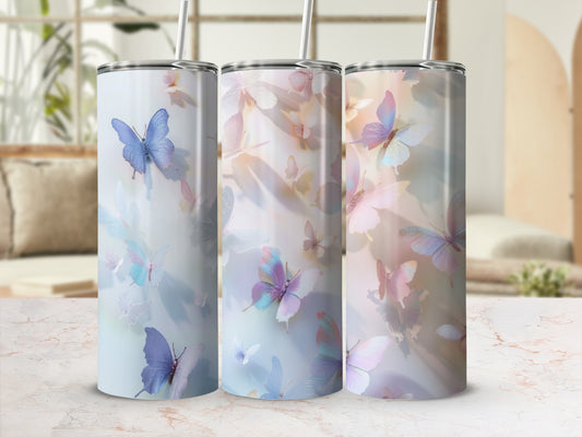 Three tumblers with pastel butterfly designs and straws.